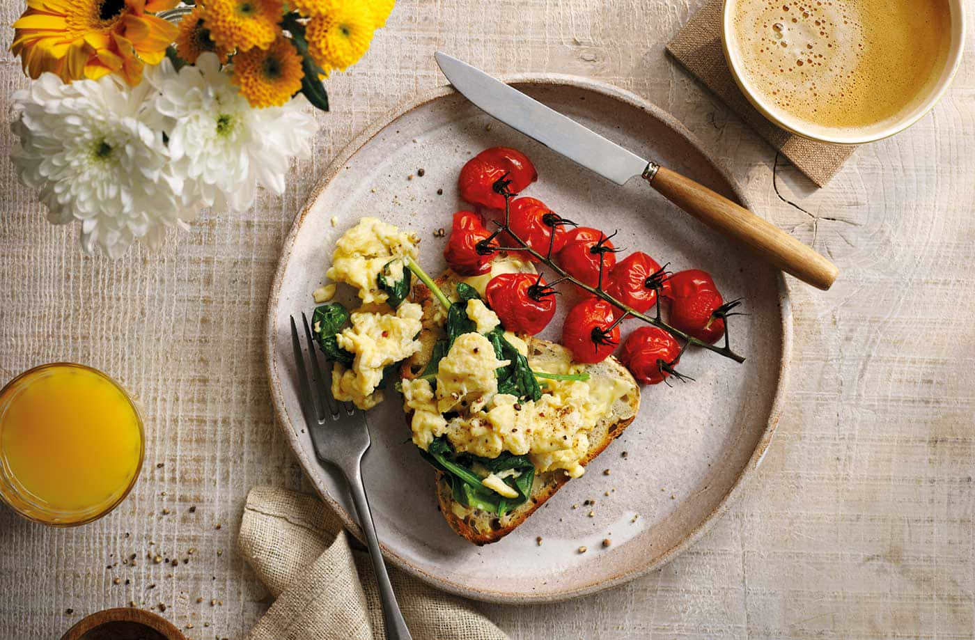 Scrambled Egg 桌布 壁紙 — 一個鄉村風格的早餐盤，有炒蛋、菠菜、吐司和烤櫻桃番茄，旁邊放著一杯咖啡和柳橙汁。
