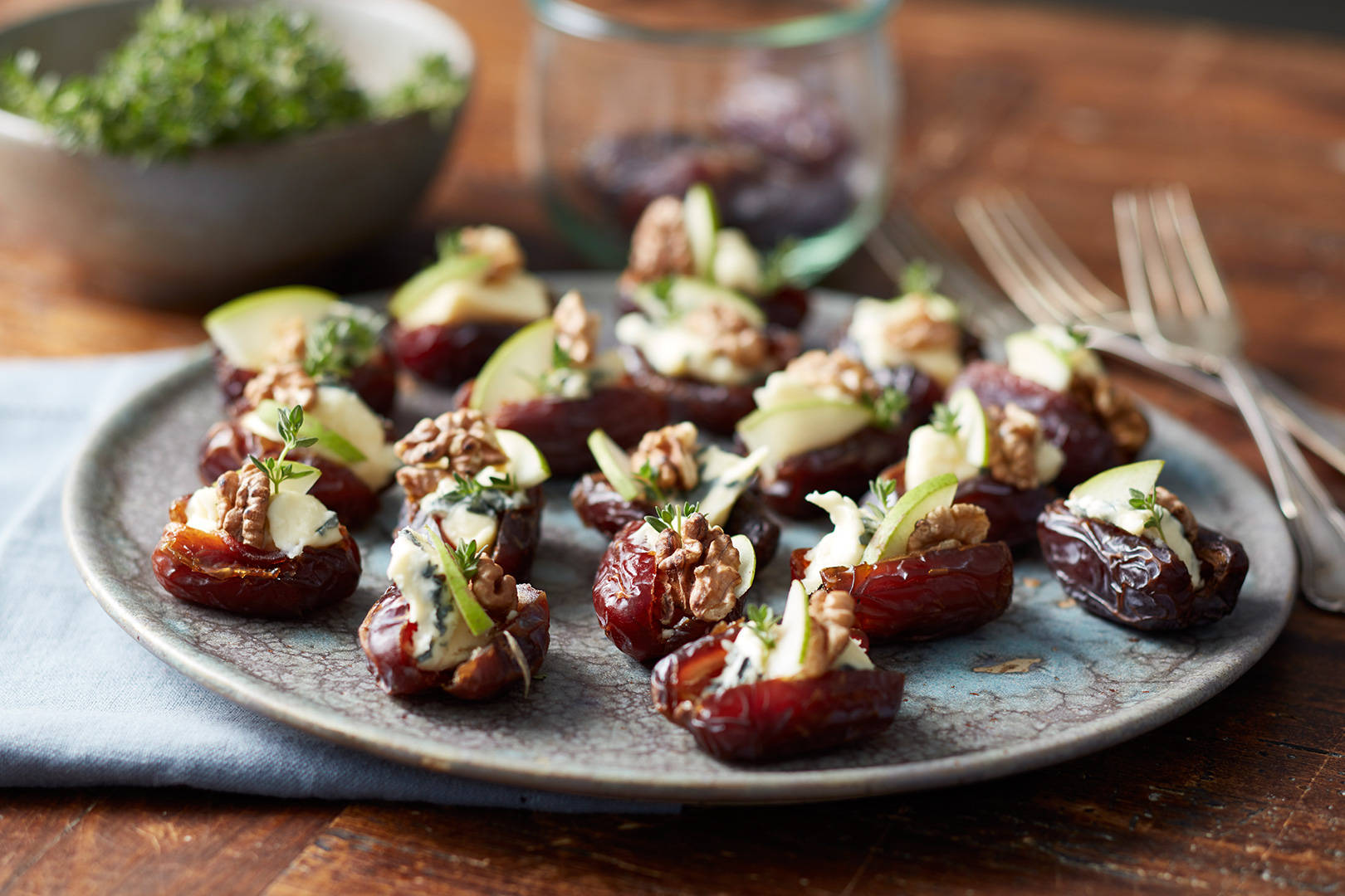 dates 桌布 壁紙 — 一個鄉村風格的盤子，上面有釀棗，配上奶油起司、切片蘋果和切碎的核桃。
