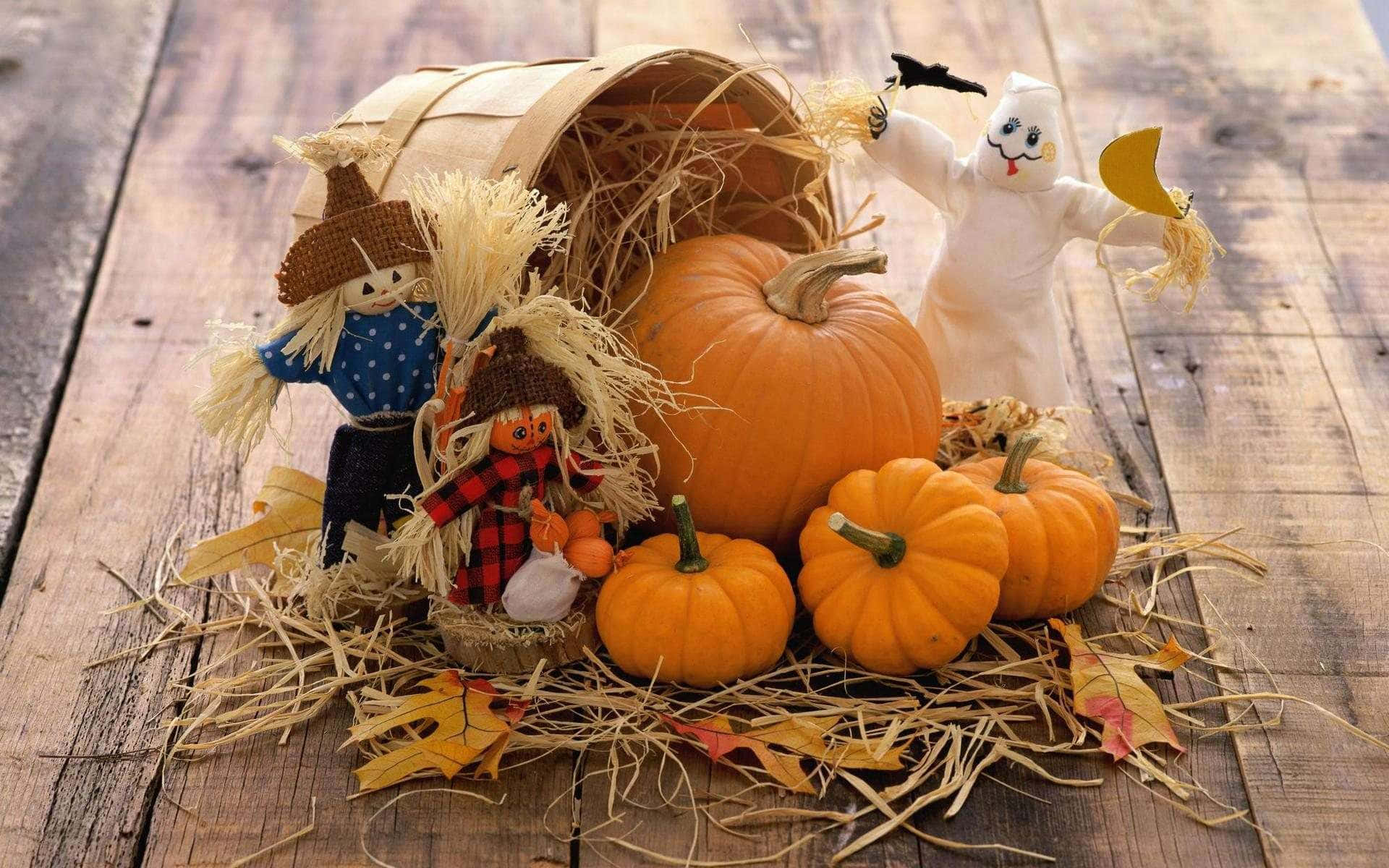 Fall Pumpkin 桌布 壁紙 — 一個鄉村風格的秋季場景，南瓜、稻草人和鬼魂公仔排列在木板上，配有乾草和落葉。