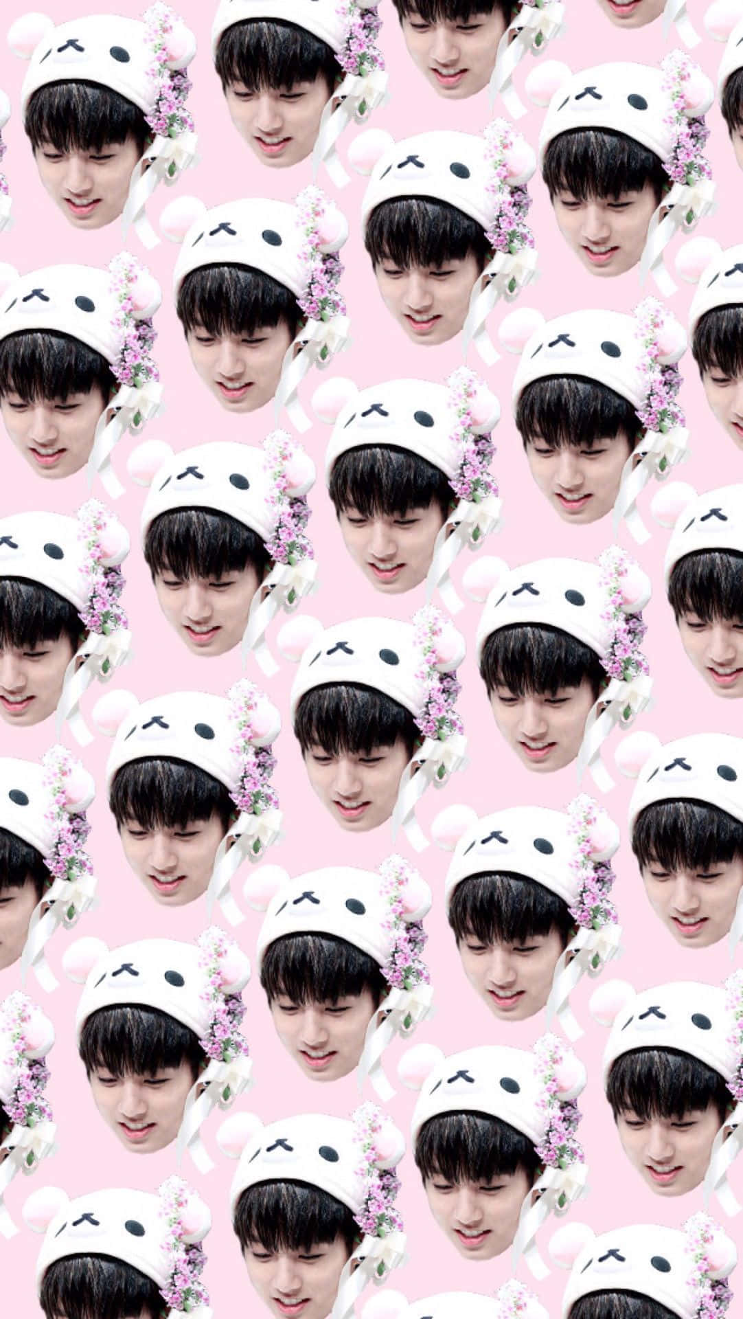 Bts Funny 桌布 壁紙 — 一個重複圖案，描繪一位年輕男子戴著白色兔子帽，帽上有粉紅色花朵，背景為柔和粉紅色。