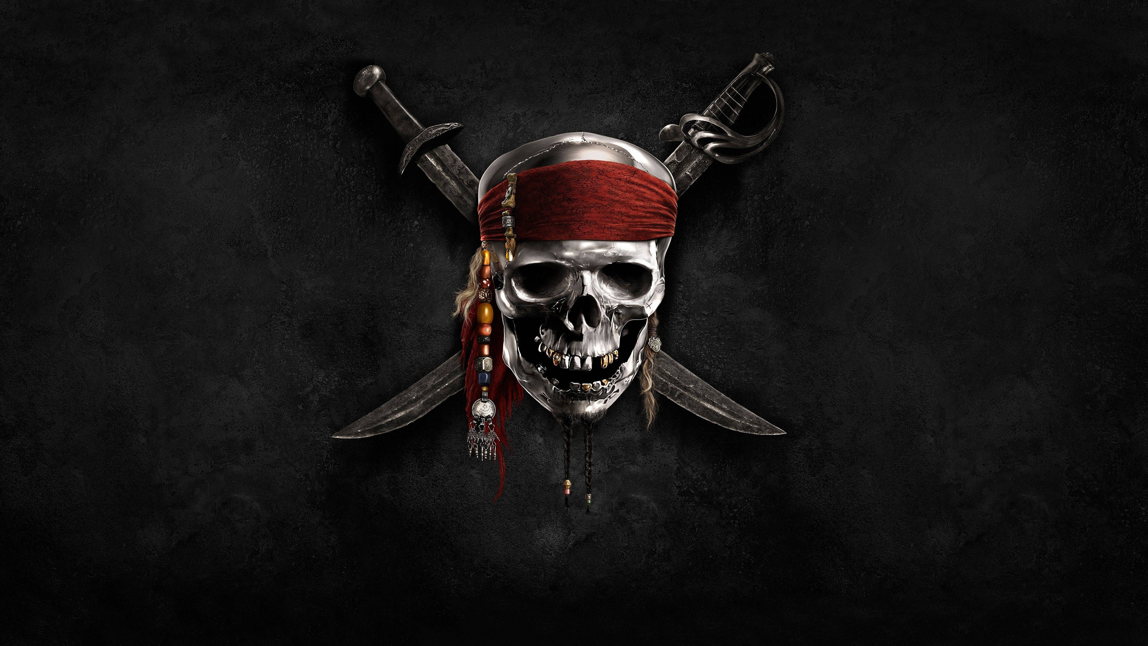 Pirates Of The Caribbean 桌布 壁紙 — 一個金屬海盜頭骨，戴著紅色頭巾和珠子，安放在兩把交叉的劍之間，背景是深色紋理。