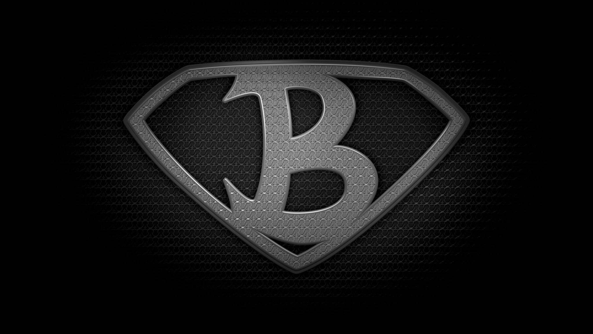 字母B 桌布 壁紙 — 一個金屬灰色的「B」標誌，呈超人盾牌形狀，在深色紋理背景上微微發光。