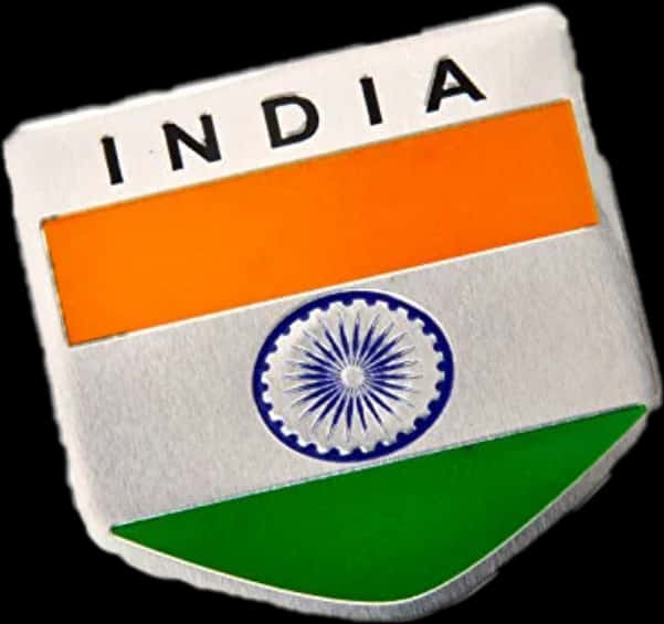India Flag 桌布 壁紙 — 一個金屬盾牌徽章，展示印度國旗，帶有藏紅花、白色和綠色條紋，以及藍色阿育王法輪，背景為黑色。