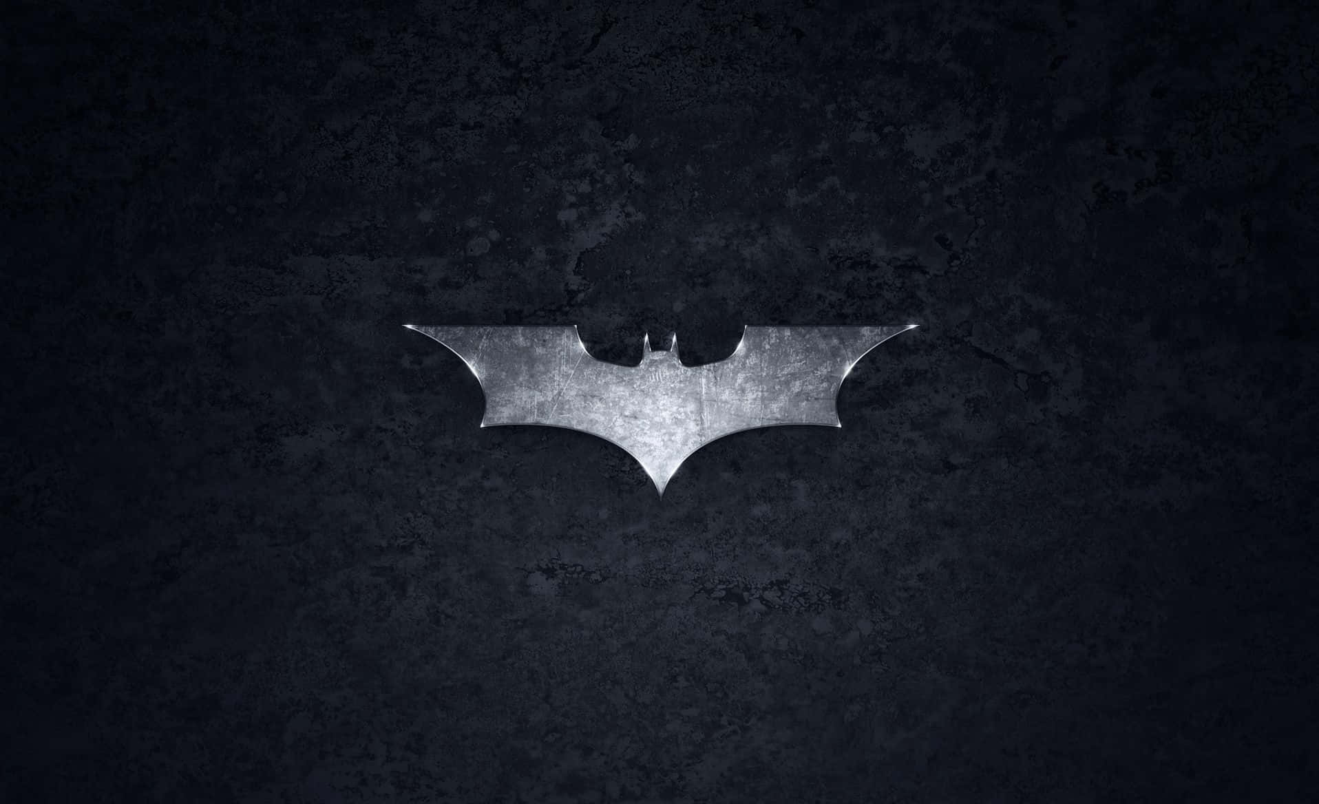 bat 桌布 壁紙 — 一個金屬蝙蝠標誌在黑暗紋理牆壁上閃耀，處於粗糙的城市環境中。