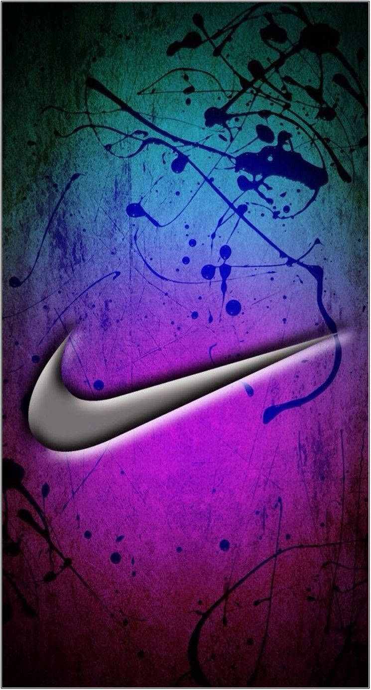 酷炫耐吉 桌布 壁紙 — 一個金屬質感的Nike勾號在充滿活力的紫藍色漸變背景上發光，背景上濺有黑色墨水和刮痕。