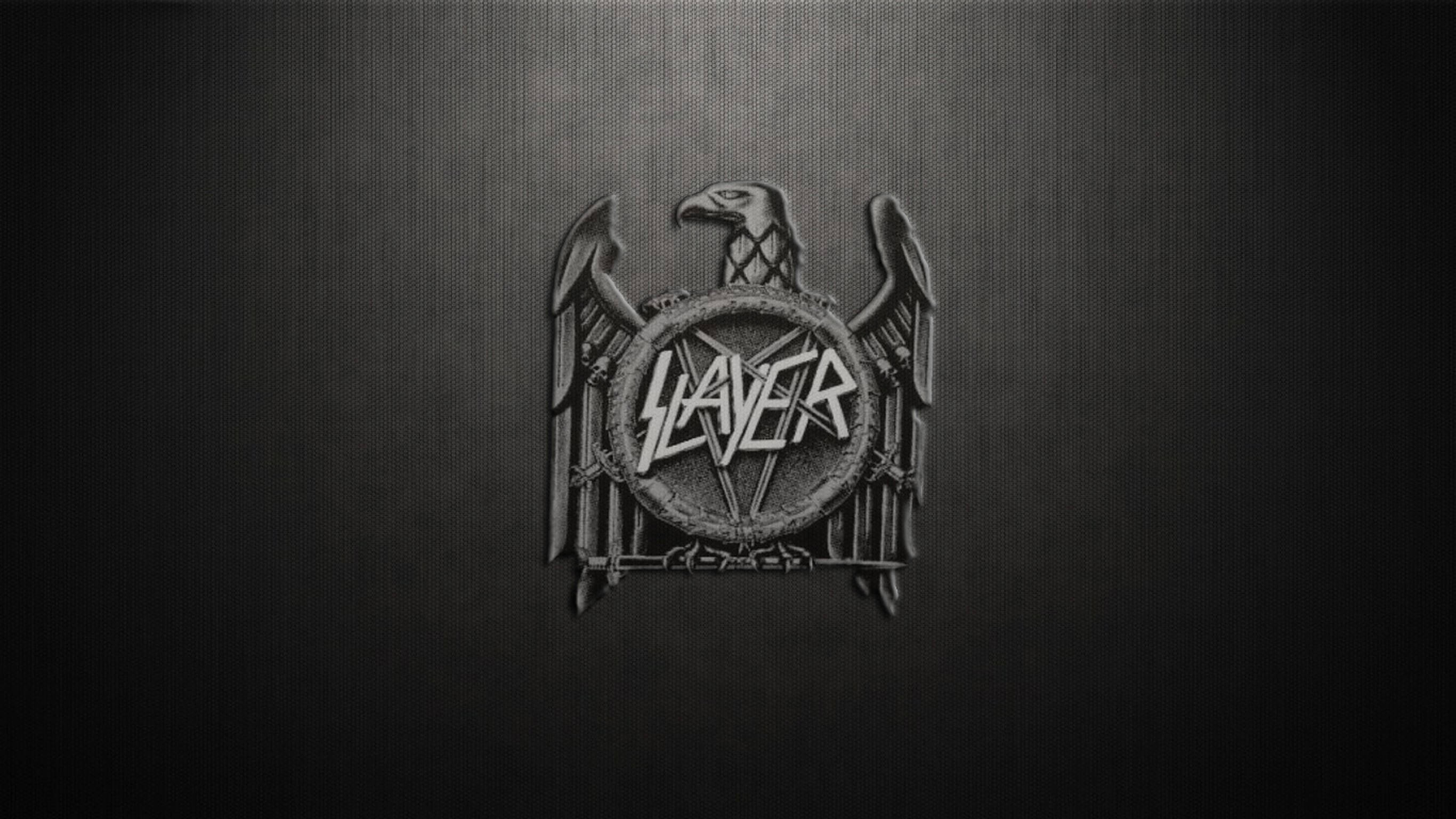 殺手 桌布 壁紙 — 一個金屬質感的Slayer標誌，中央有鷹徽，置於深色紋理背景上。