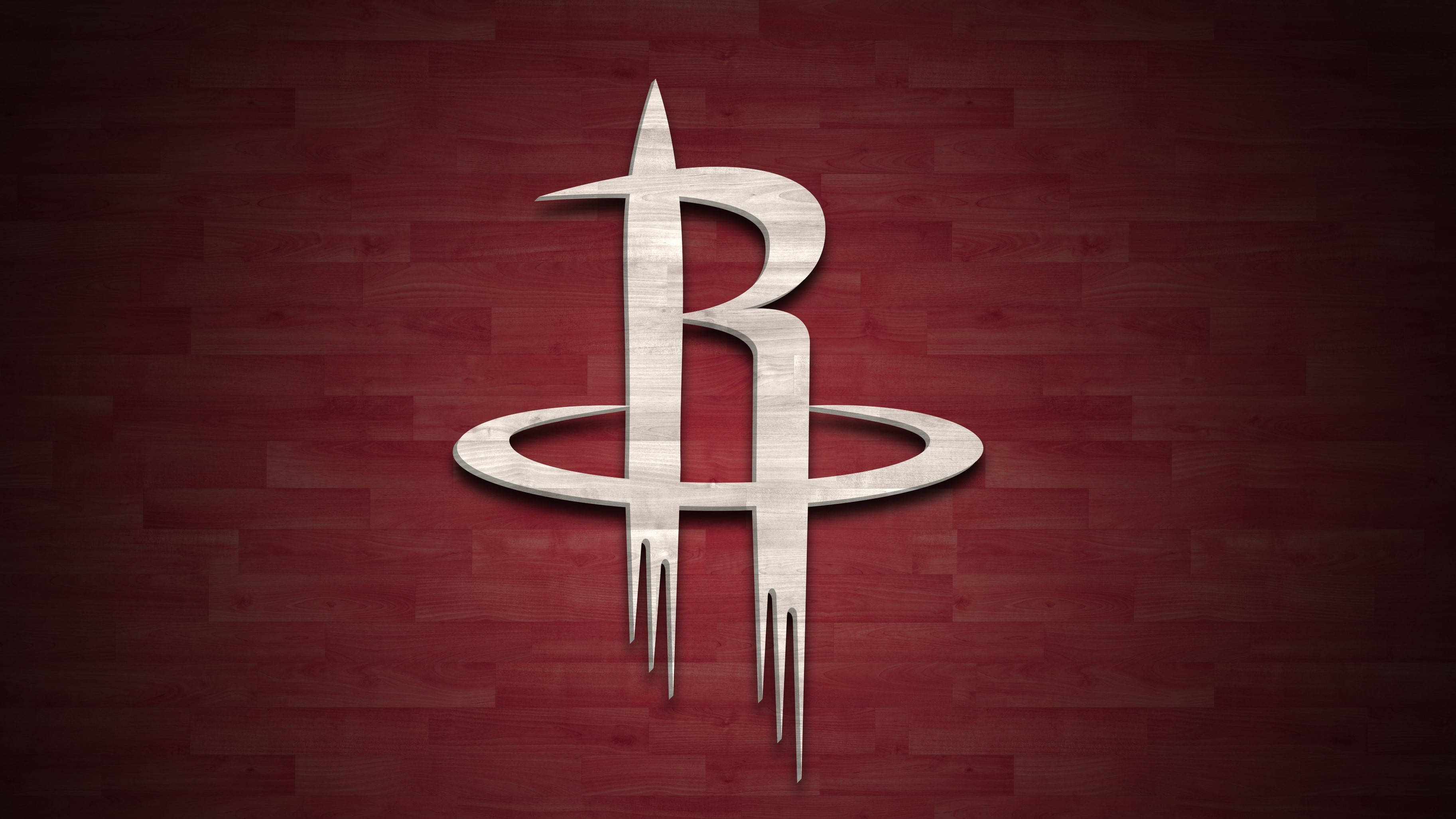 Houston Rockets 桌布 壁紙 — 一個金屬質感的休士頓火箭隊標誌在豐富的紅色木地板背景上閃耀。