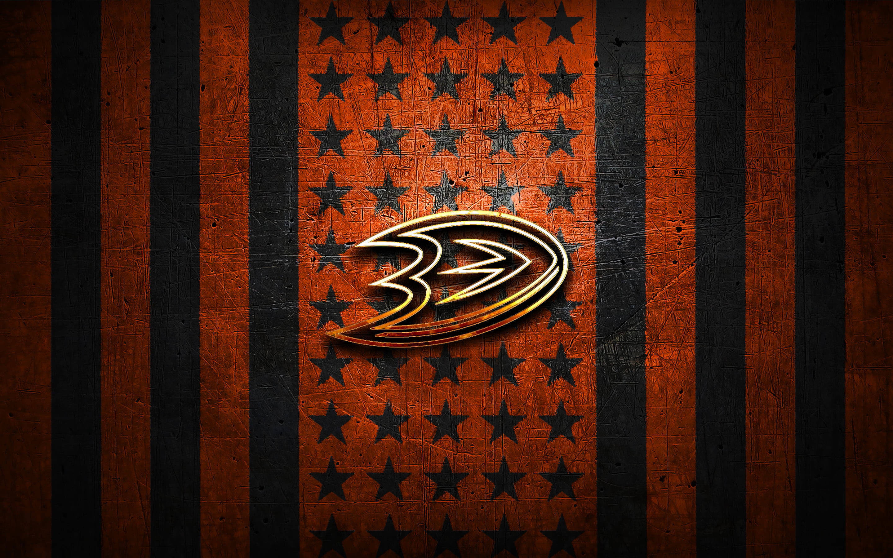 ducks 桌布 壁紙 — 一個金屬質感的安納海姆鴨隊（Anaheim Ducks）標誌，在帶有星星圖案的陳舊橙色和黑色條紋背景上閃耀。