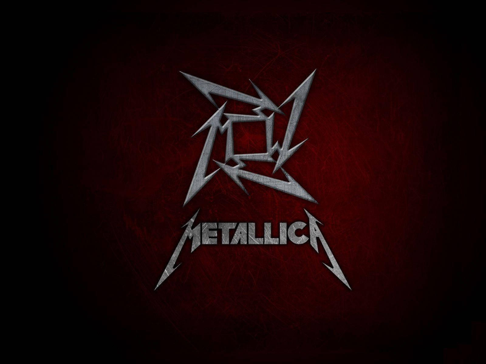 金屬製品樂團 桌布 壁紙 — 一個金屬銀色 Metallica 標誌，帶有鋸齒狀閃電，在紋理深紅色背景上發光。