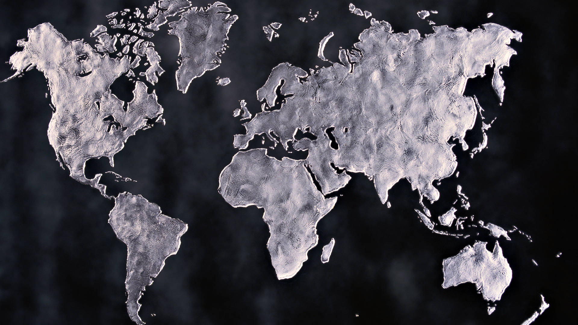 United States Map 桌布 壁紙 — 一個金屬銀色世界地圖，帶有紋理的大陸，漂浮在黑暗煙霧背景上。