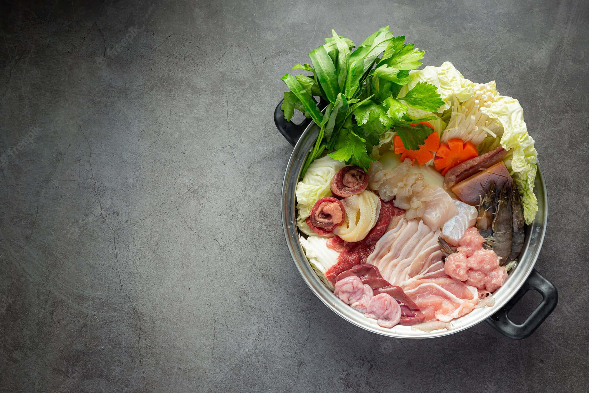 meat 桌布 壁紙 — 一個金屬鍋裝滿生肉、海鮮和新鮮蔬菜，準備在紋理灰色表面上進行火鍋烹飪。