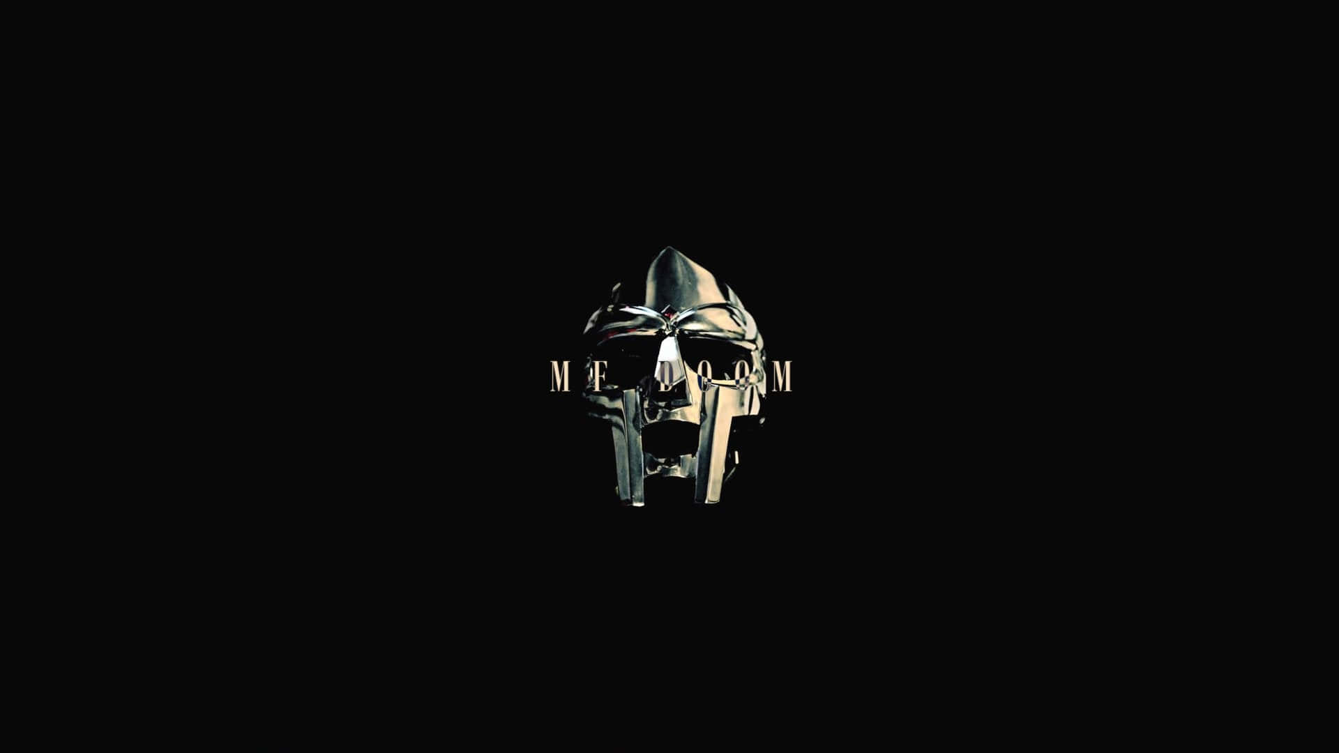 1920x1080 Doom 桌布 壁紙 — 一個金屬頭盔，帶有發光的眼睛，黑色背景上以金色字母寫著「MEGAMOM」。