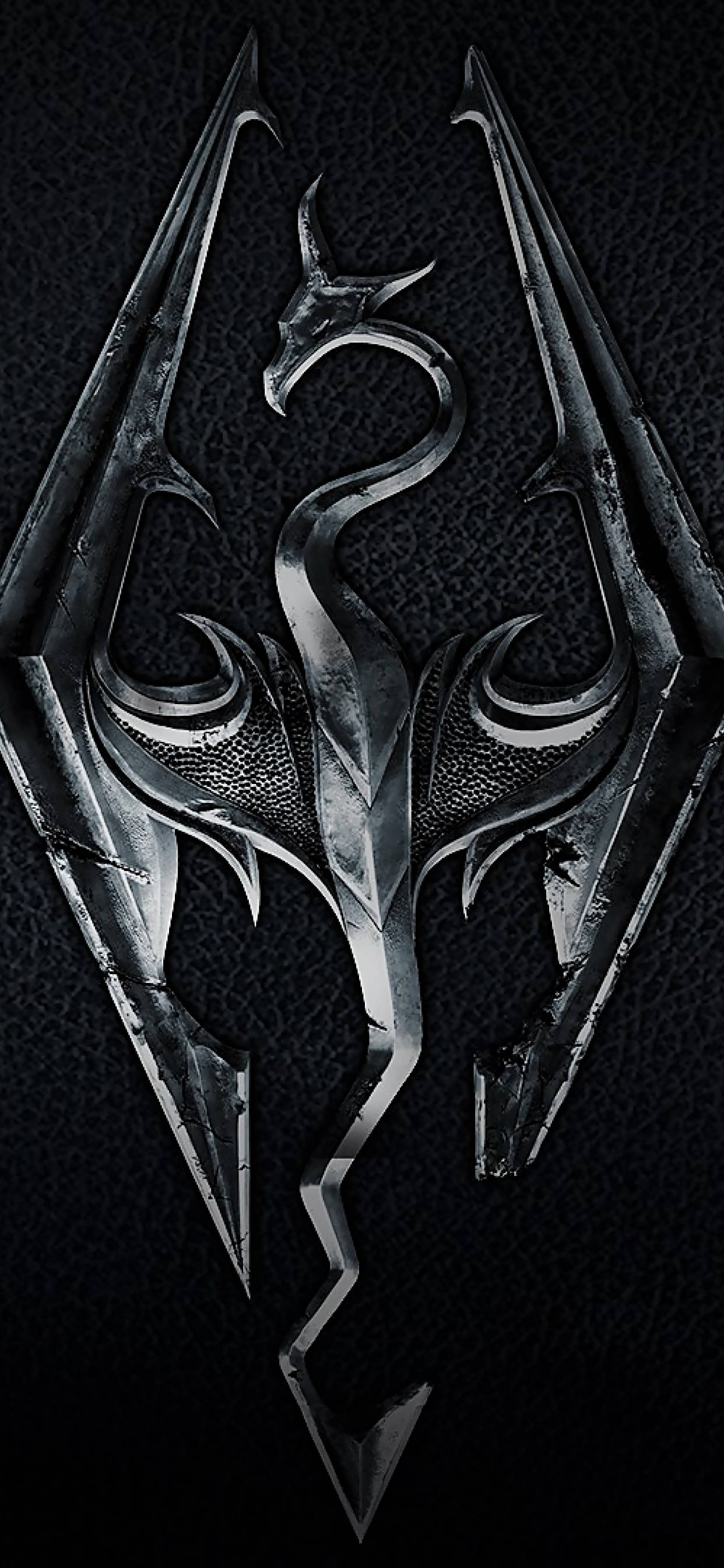 Skyrim 4K 桌布 壁紙 — 一個金屬龍紋章，帶有鋒利的翅膀和複雜的細節，在深色紋理背景上發光。