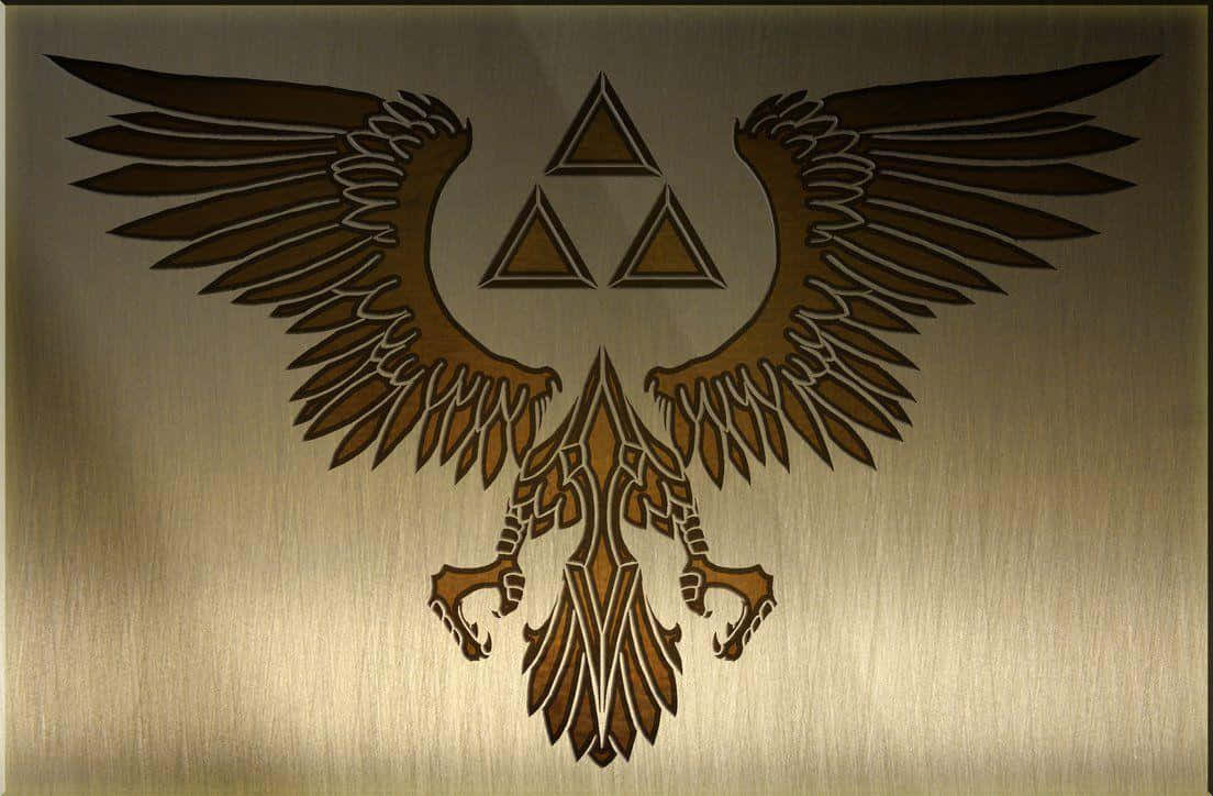 The Legend Of Zelda Hyrule 桌布 壁紙 — 一個金色三角力量標誌，帶有展開的翅膀，蝕刻在拉絲金屬上，在柔和光線下溫暖發光。