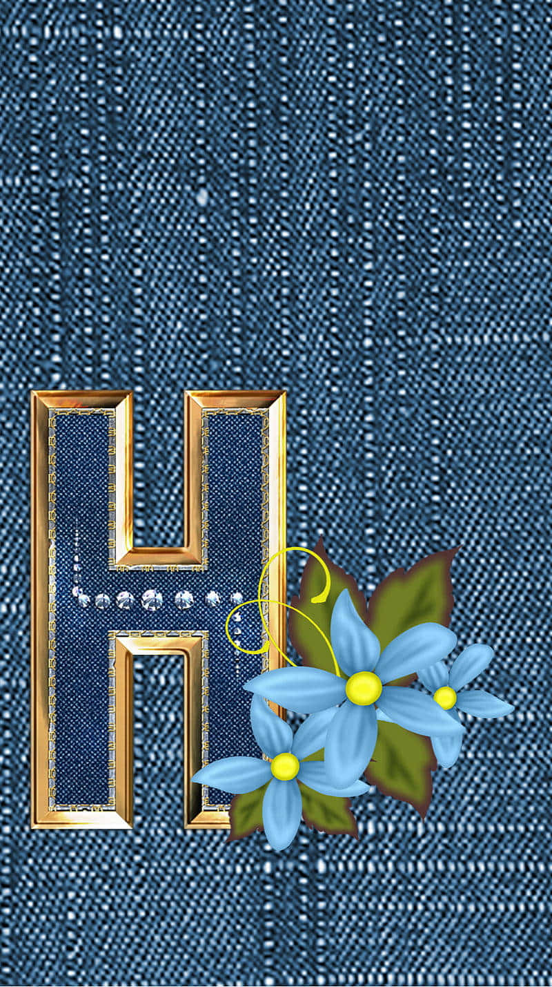Denim 桌布 壁紙 — 一個金色字母H，飾有珍珠和藍色花朵，放置在帶有紋理的牛仔布背景上。