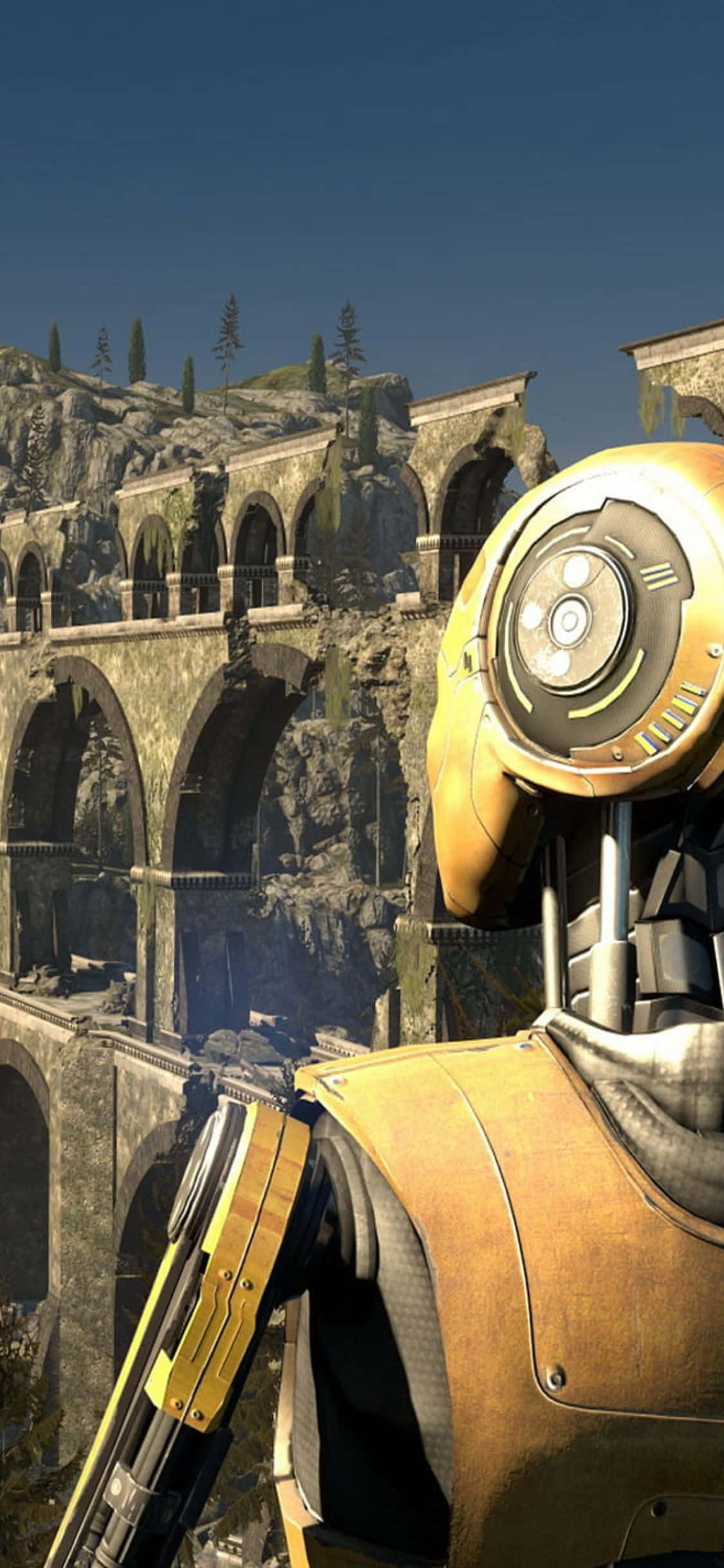 iPhone X The Talos Principle 桌布 壁紙 — 一個金色機器人站在古老的石砌水道遺跡前，背景是晴朗的藍天和稀疏的樹木。