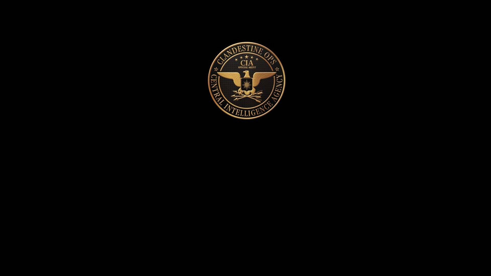 Cia 桌布 壁紙 — 一個金色的CIA秘密行動印章在純黑背景上閃耀，帶有銳利的金屬細節。