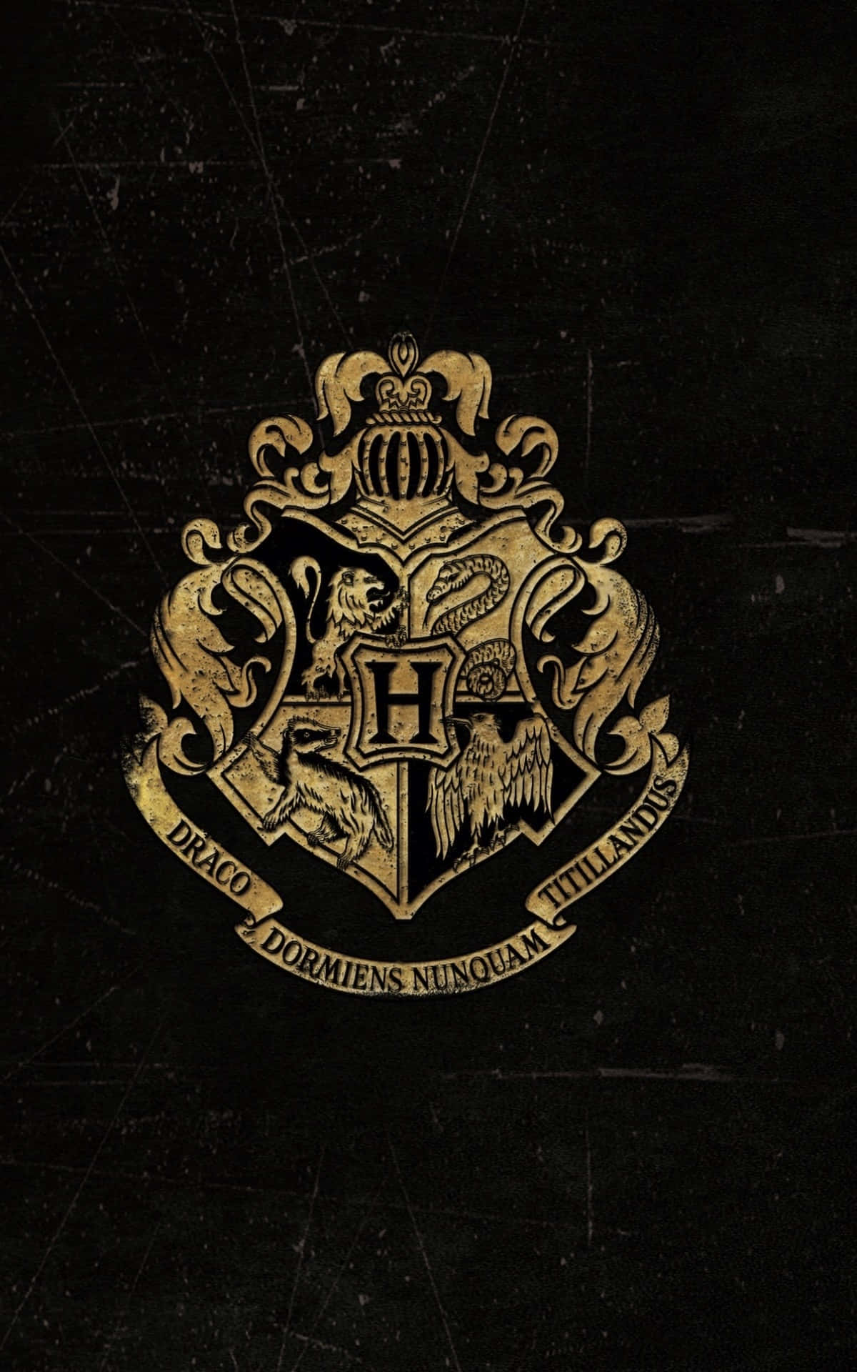 Hogwarts Crest 桌布 壁紙 — 一個金色的霍格華茲校徽在帶有細微刮痕和磨損的紋理黑色背景上閃耀。