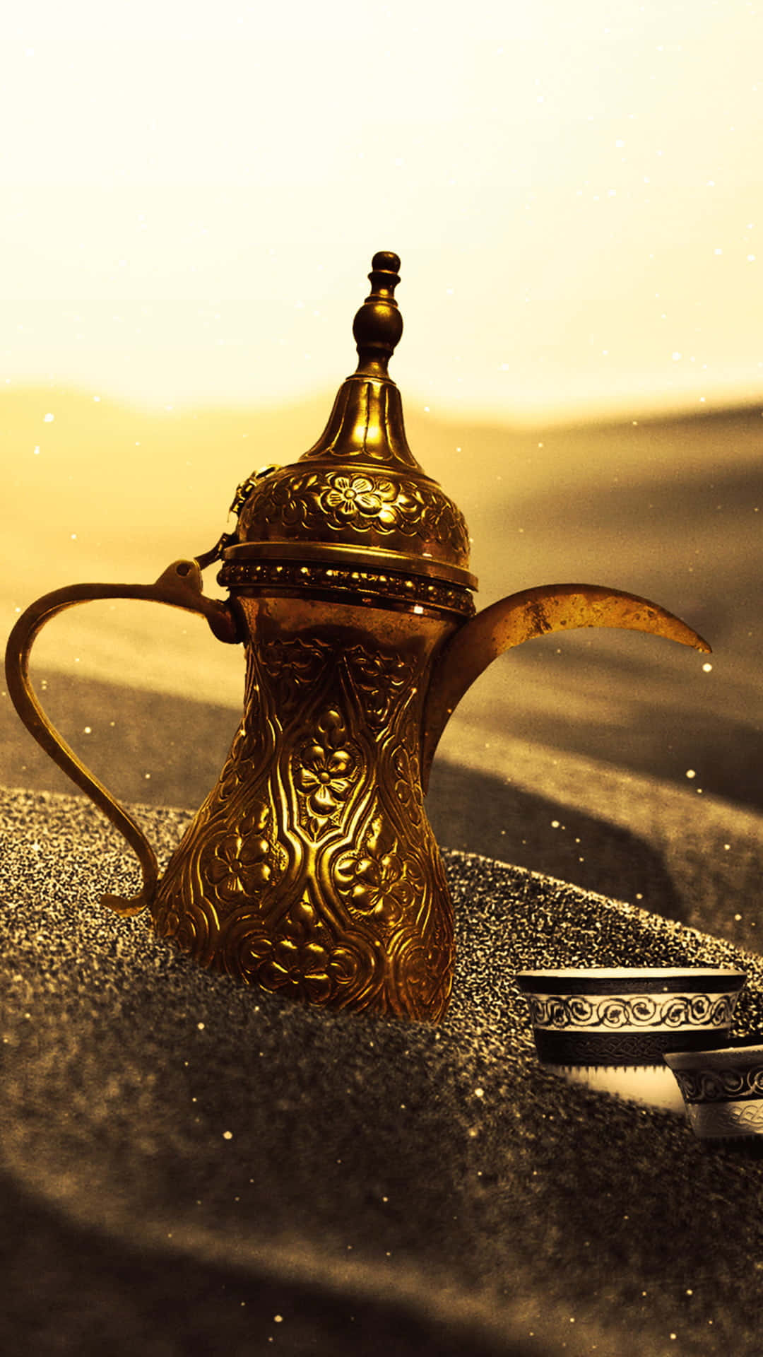 arabic 桌布 壁紙 — 一個金色華麗的阿拉伯咖啡壺放在沙上，背後有溫暖發光的日落。
