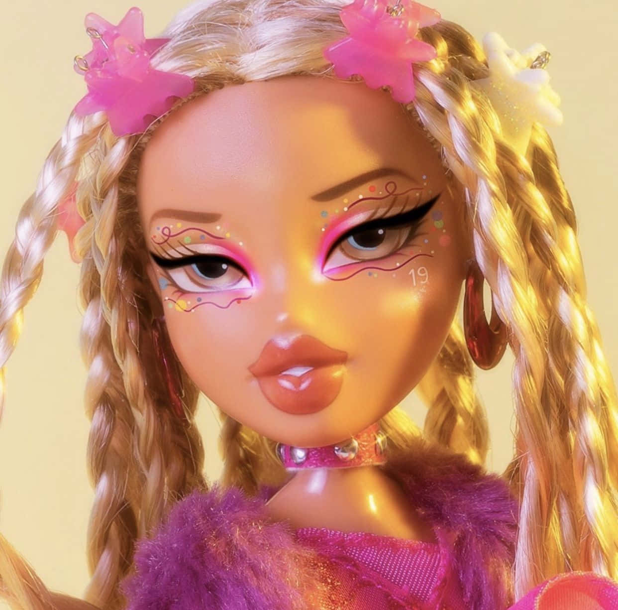 Bratz 桌布 壁紙 — 一個金色辮子頭髮飾有粉紅色星星夾和閃亮眼妝的洋娃娃，穿著鮮豔的粉紅色服裝向前凝視。