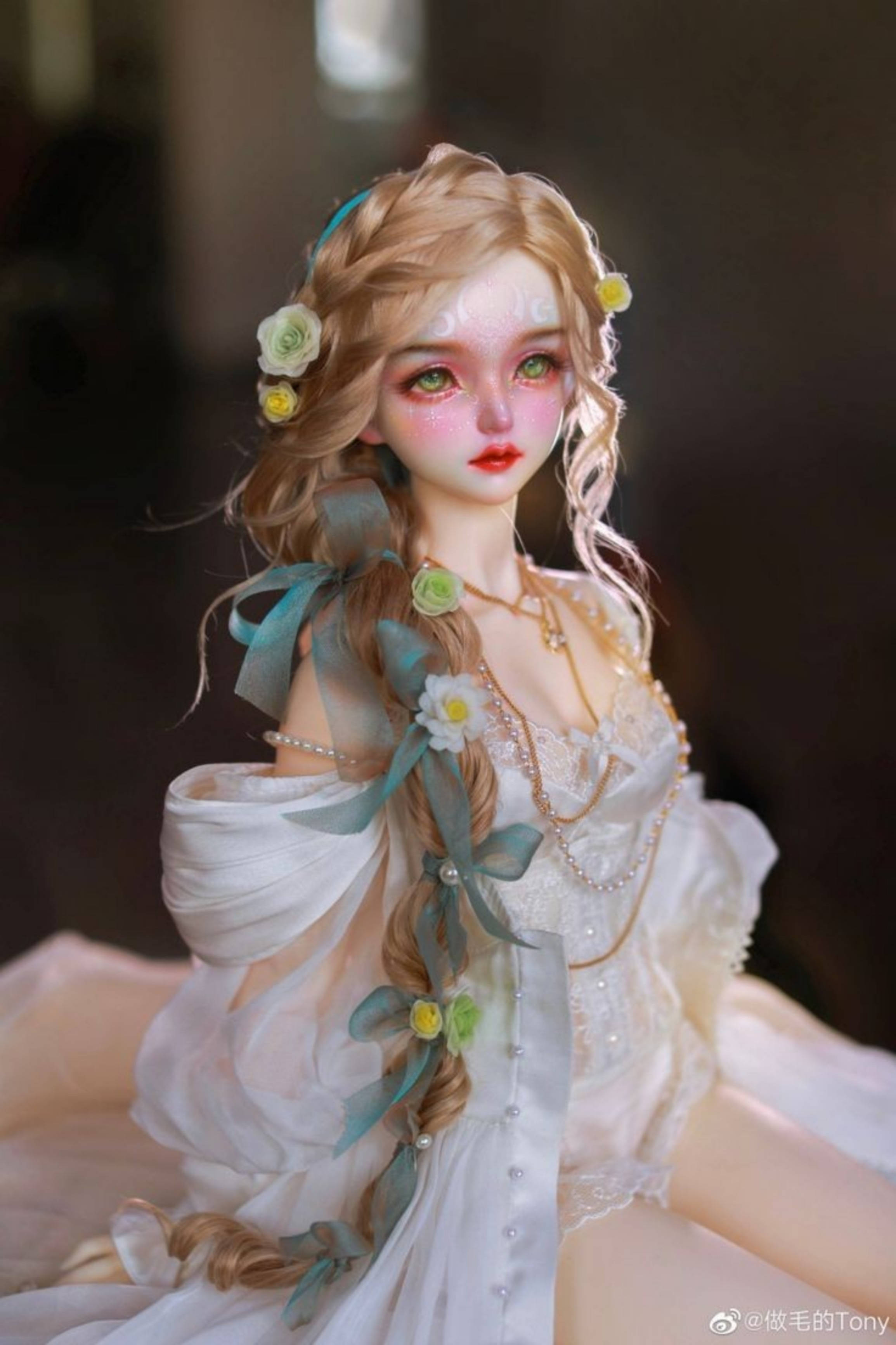 Doll 桌布 壁紙 — 一個金髮上飾有花朵和青綠色絲帶的洋娃娃，穿著帶有珍珠細節的飄逸白色長裙。