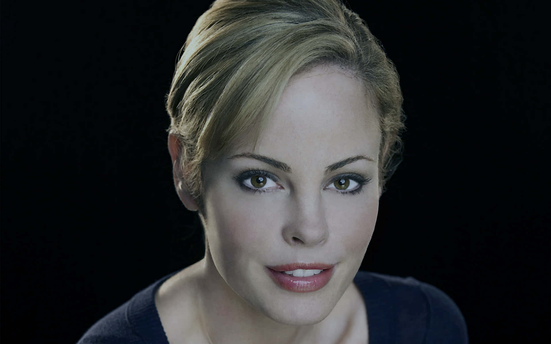 Chandra West 桌布 壁紙 — 一個金髮棕眼女性在黑色背景前的特寫肖像。