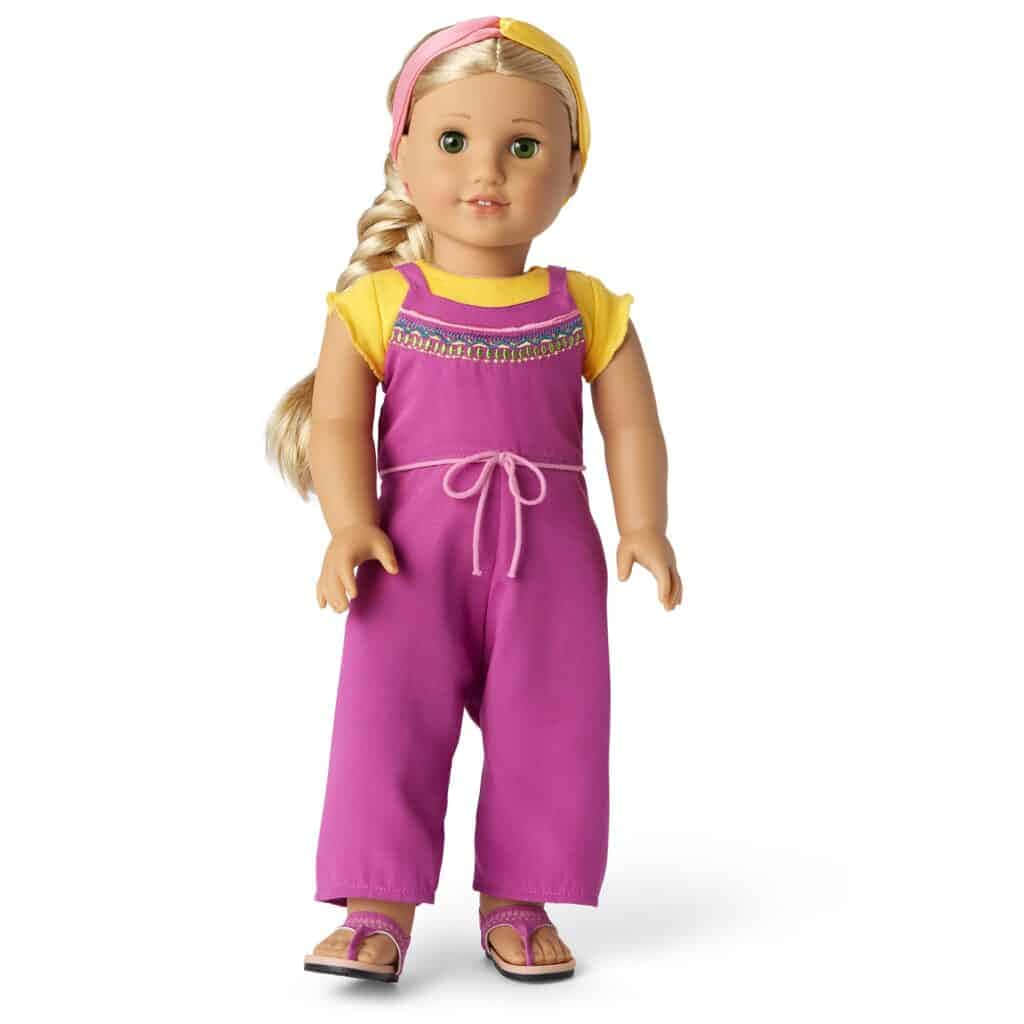 american girl 桌布 壁紙 — 一個金髮辮子、綠眼睛的洋娃娃，穿著鮮豔的紫色連身褲，搭配黃色袖子和粉紅色涼鞋，背景是純白色。