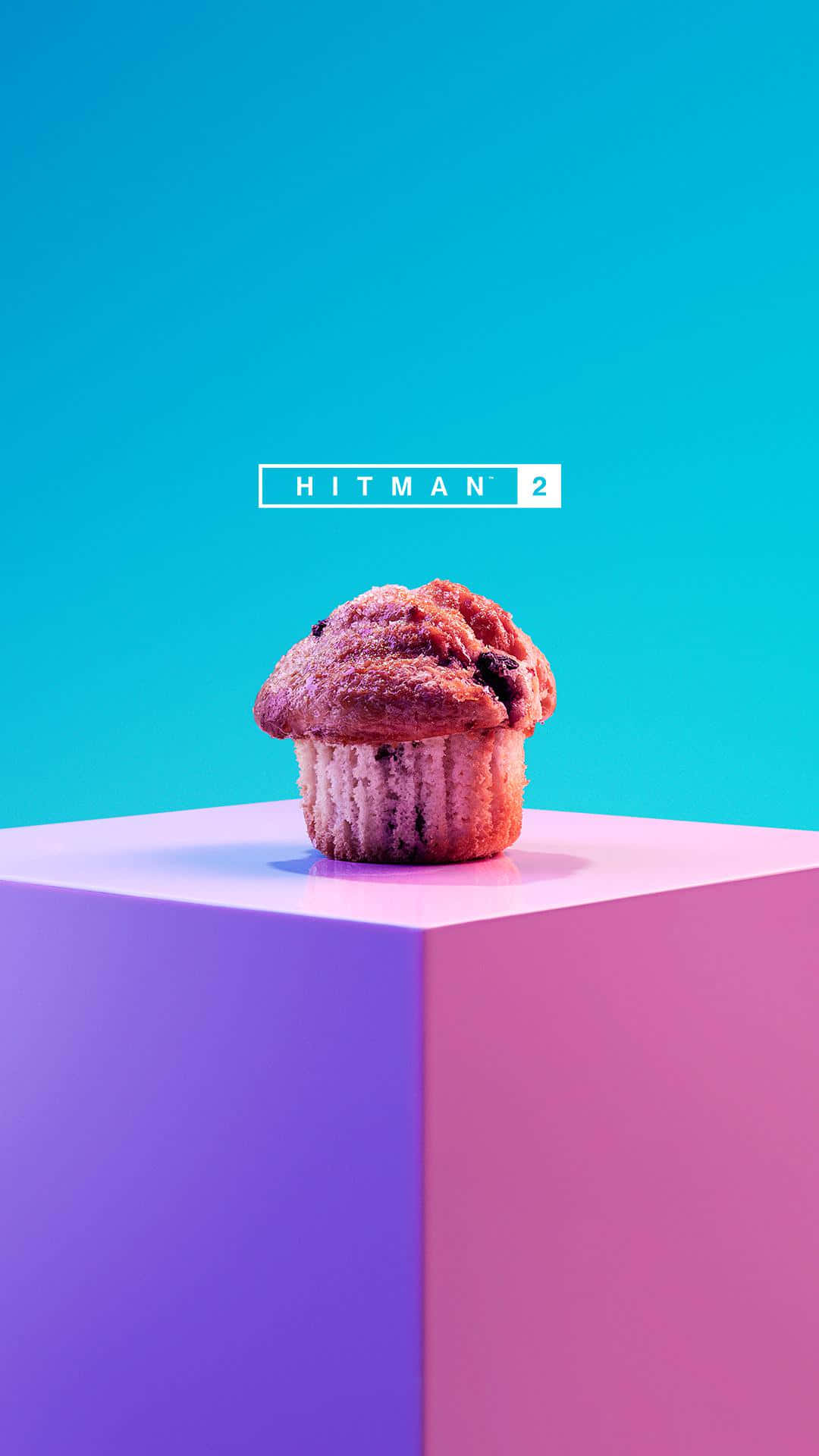 Best Hitman 2 桌布 壁紙 — 一個金黃色的巧克力碎片鬆餅放在鮮豔的粉紅色和紫色幾何圖案方塊上，背景是明亮的青色，並帶有「HITMAN 2」文字。