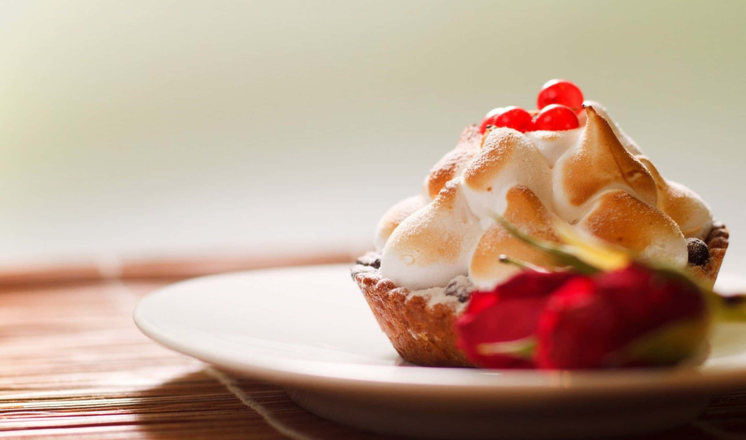 2440x1440 Desserts 桌布 壁紙 — 一個金黃色的蛋白霜餡餅，上面綴滿紅色漿果，放在白色盤子上，旁邊有一朵紅玫瑰。