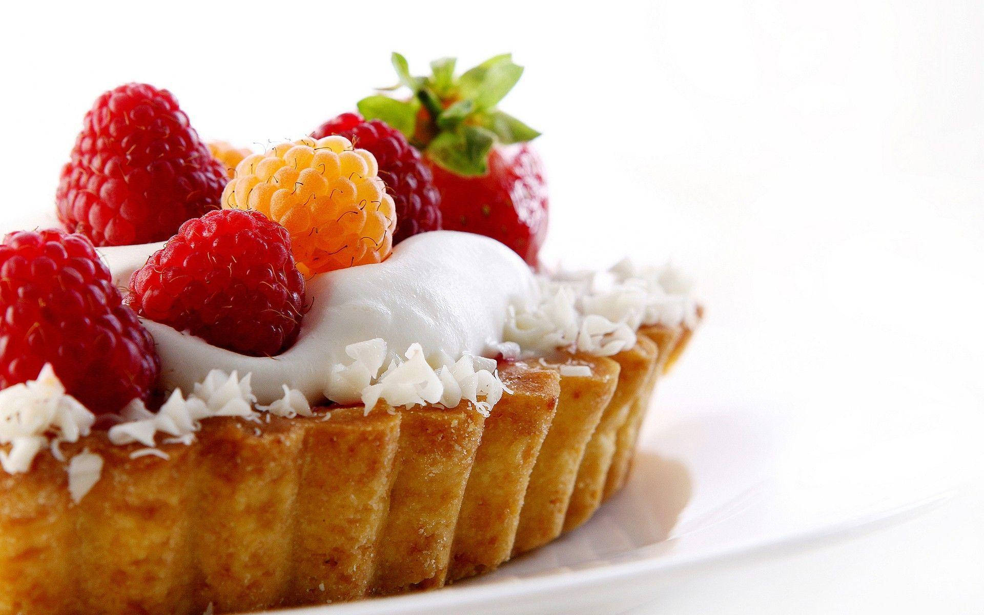Pastry 桌布 壁紙 — 一個金黃色的酥皮撻，上面鋪滿新鮮的覆盆子、草莓和鮮奶油，襯托在明亮的白色背景上。