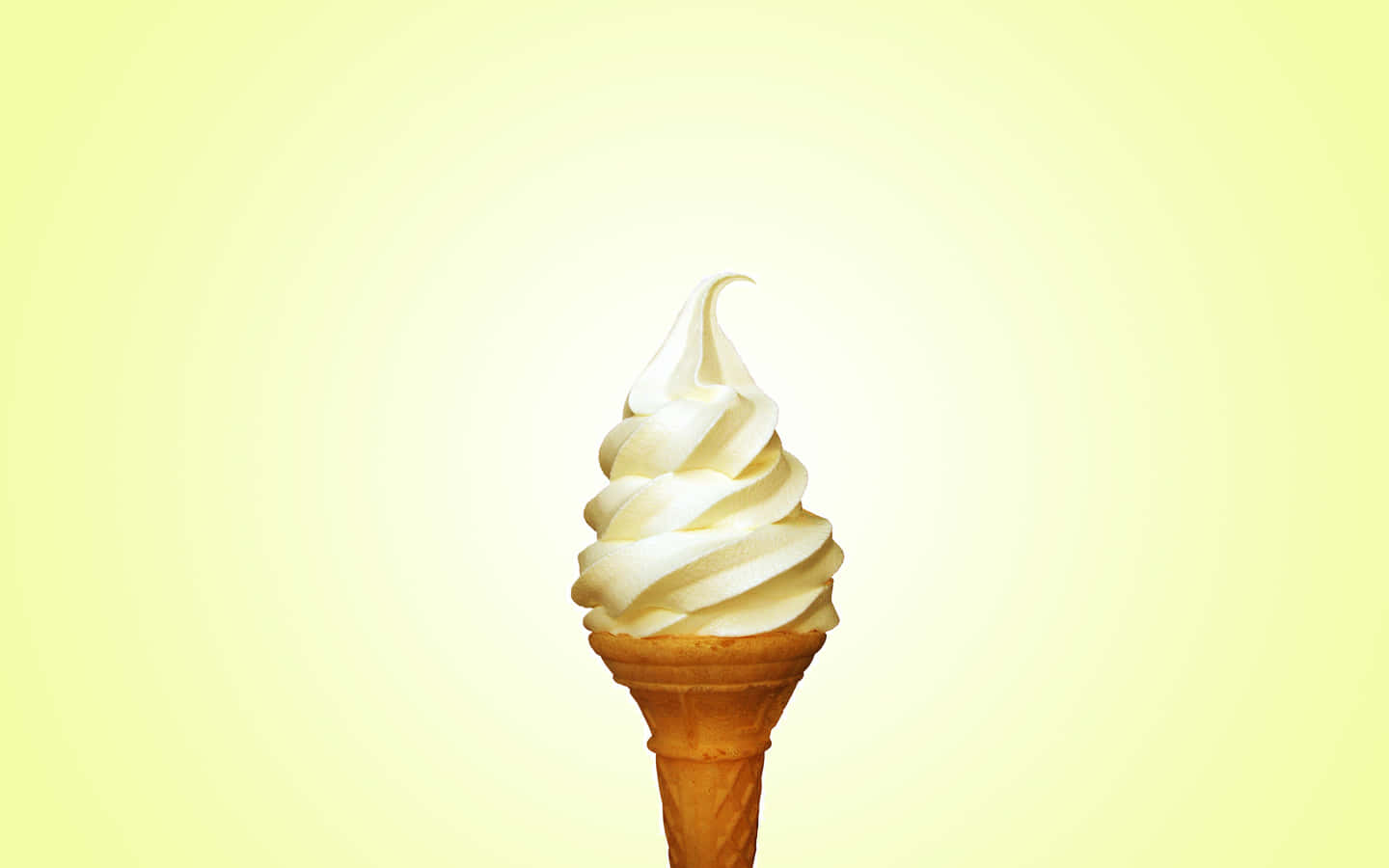 Ice Cream 桌布 壁紙 — 一個金黃色鬆餅筒上的奶油香草軟冰淇淋漩渦，背景是柔和的黃色漸層。