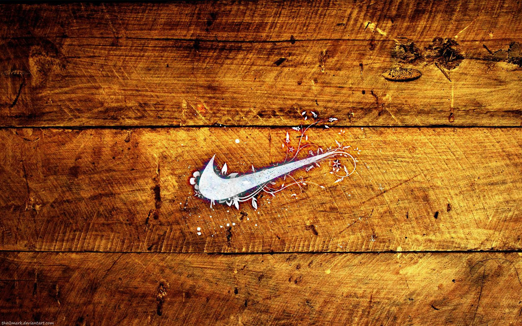酷棒球 桌布 壁紙 — 一個銀色Nike swoosh標誌濺上白色油漆，放置在帶有豐富琥珀色調的風化木板上。