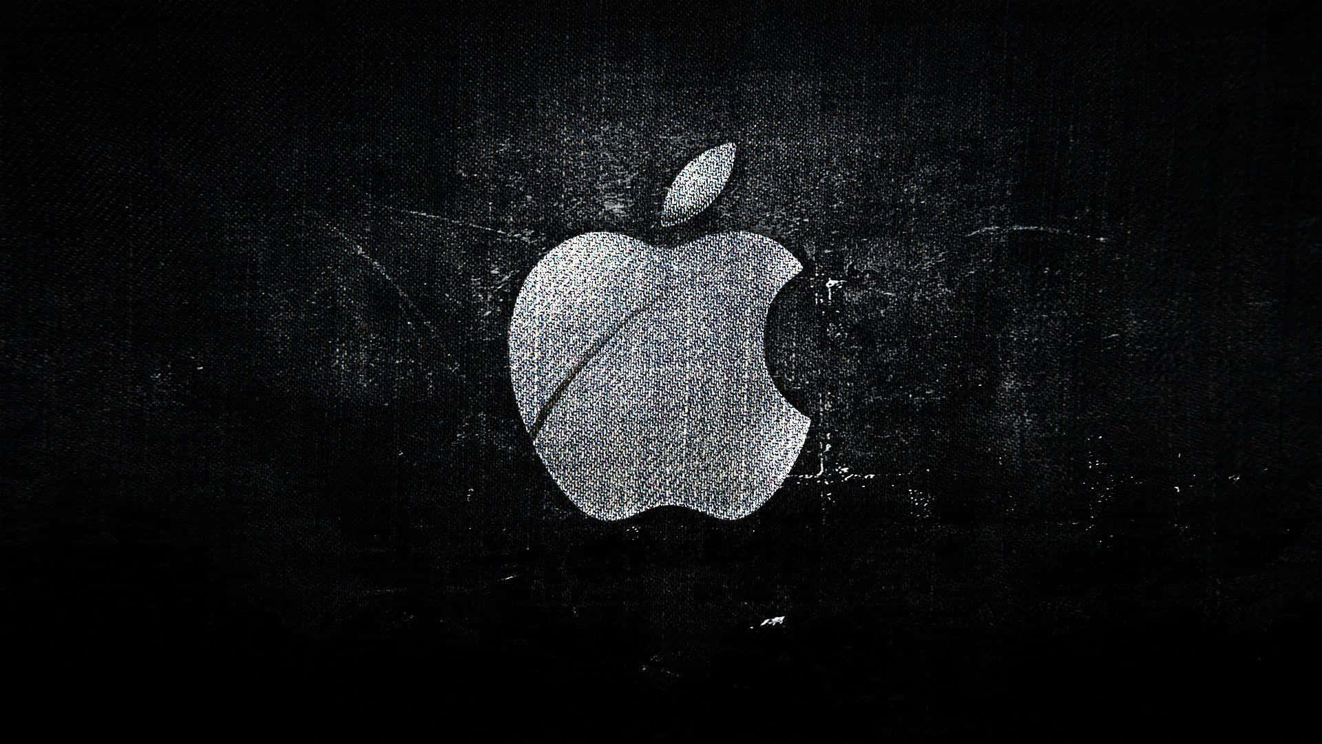 桌布 壁紙 — 一個銀色的Apple標誌帶有咬痕，在有紋理的深色背景上微微發光。