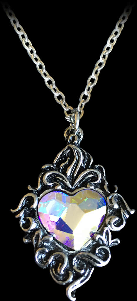 Necklace 桌布 壁紙 — 一個銀色鏤空心形吊墜，中心鑲有彩虹色水晶，掛在鏈條上，背景為黑色。
