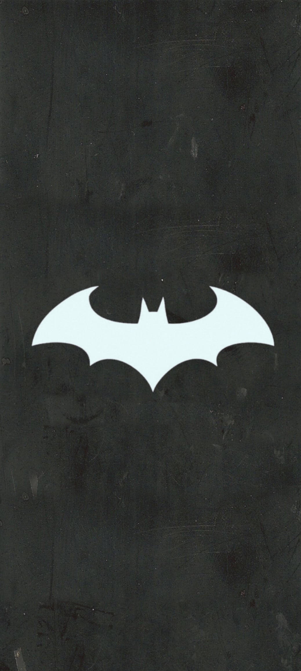 Batman Logo 桌布 壁紙 — 一個銳利的白色蝙蝠標誌在帶有細微刮痕和污漬的紋理深灰色牆壁上發光。