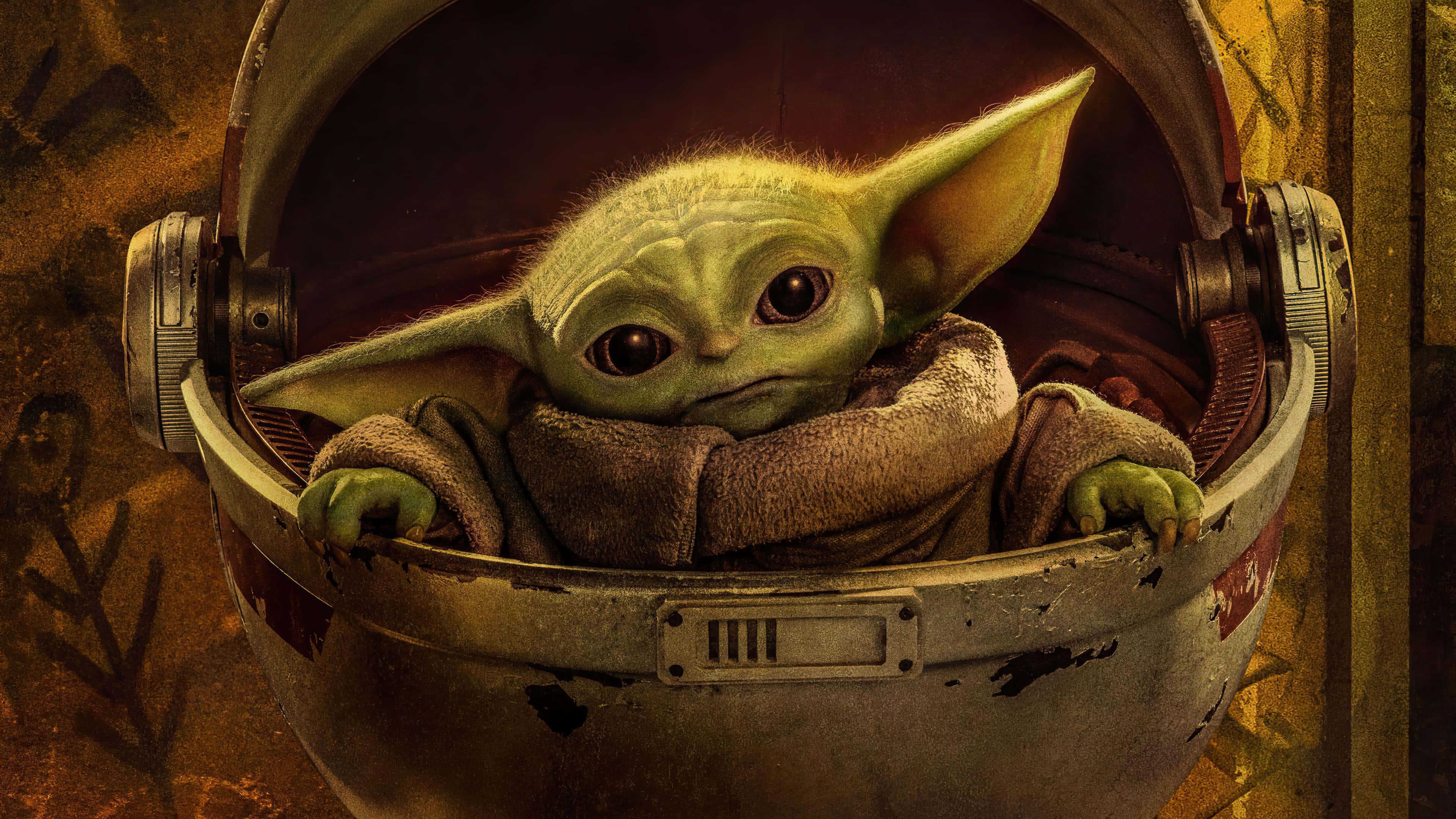 Mandalorian Yoda 桌布 壁紙 — 一個長著大耳朵的小綠色外星人，好奇地從一個破舊的金屬頭盔裡探出頭來。