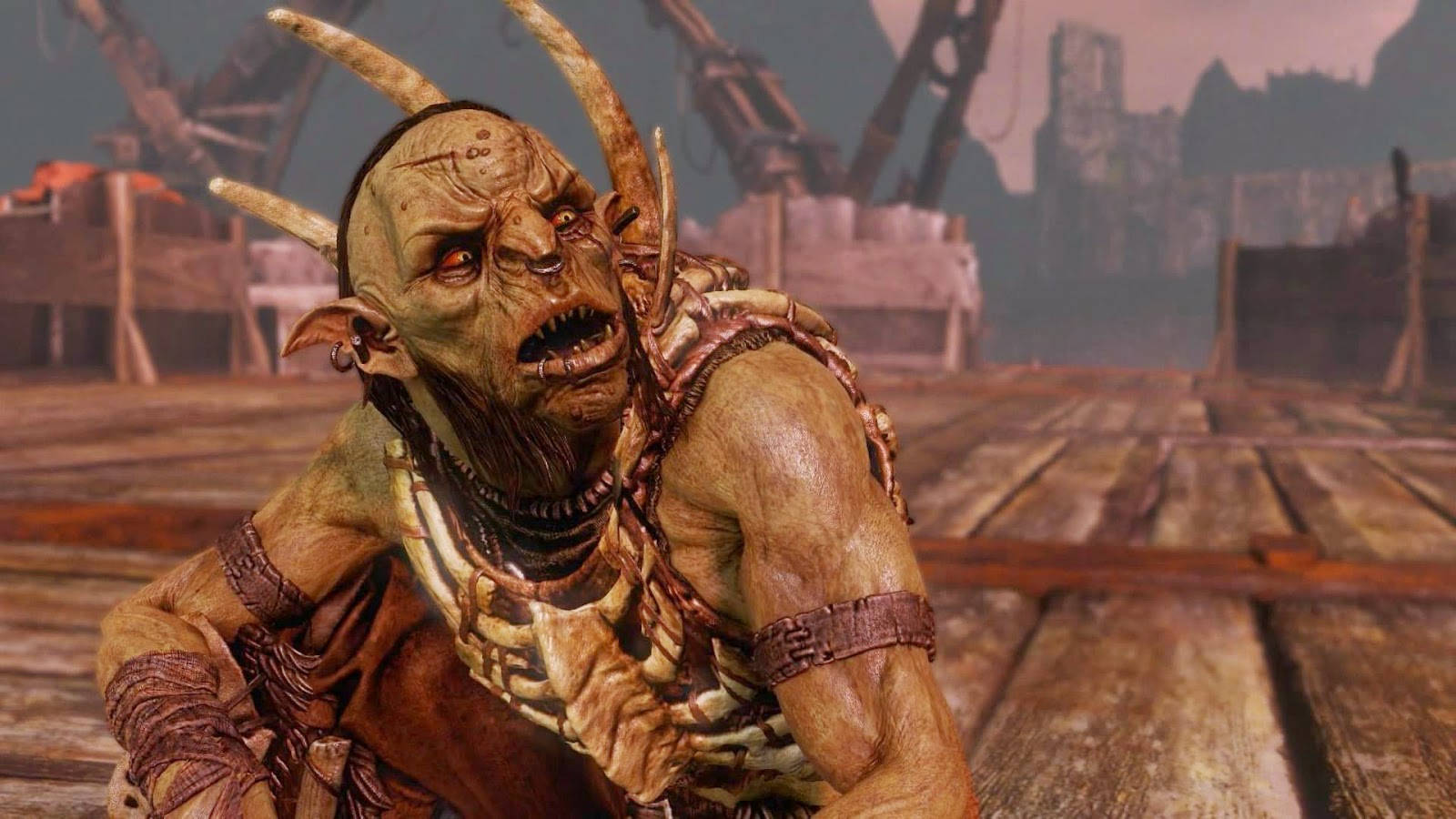 middle earth shadow of war 桌布 壁紙 — 一個長著角、牙齒鋒利、帶有部落裝飾的怪獸般獸人蹲在一個飽經風霜的木甲板上，背景是荒涼、戰火摧殘的場景。