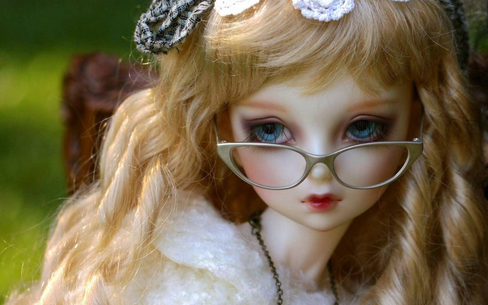 Doll 桌布 壁紙 — 一個長金髮戴眼鏡的娃娃在柔和自然光下坐在戶外的特寫。