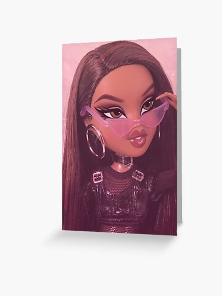 Bratz 桌布 壁紙 — 一個長長深色頭髮、戴著粉紅色太陽眼鏡的洋娃娃，在柔和的粉紅色背景前調整她的眼鏡。