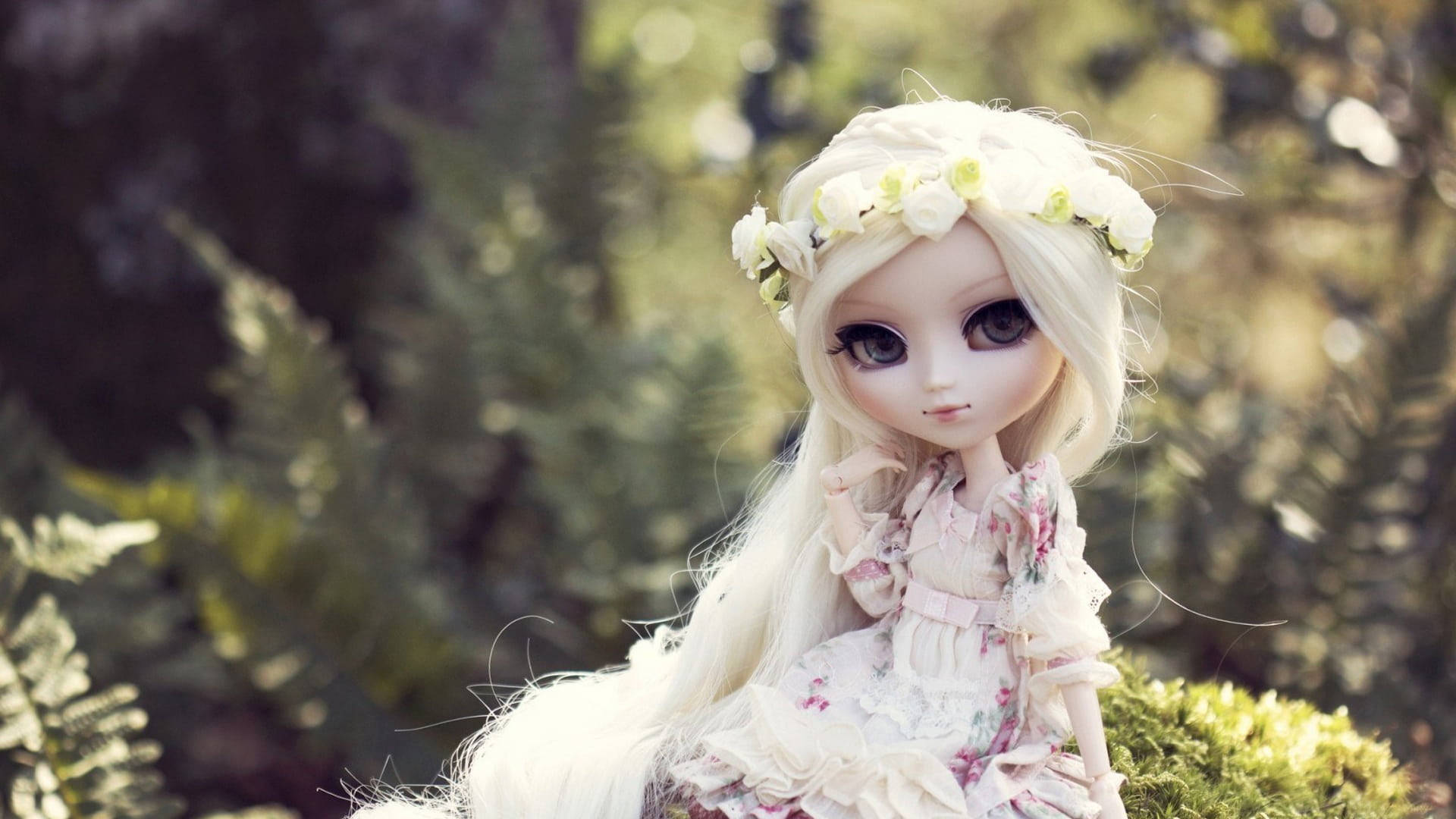 Doll 桌布 壁紙 — 一個長長金髮、戴著花冠的洋娃娃優雅地坐在陽光普照、綠意盎然的花園中。