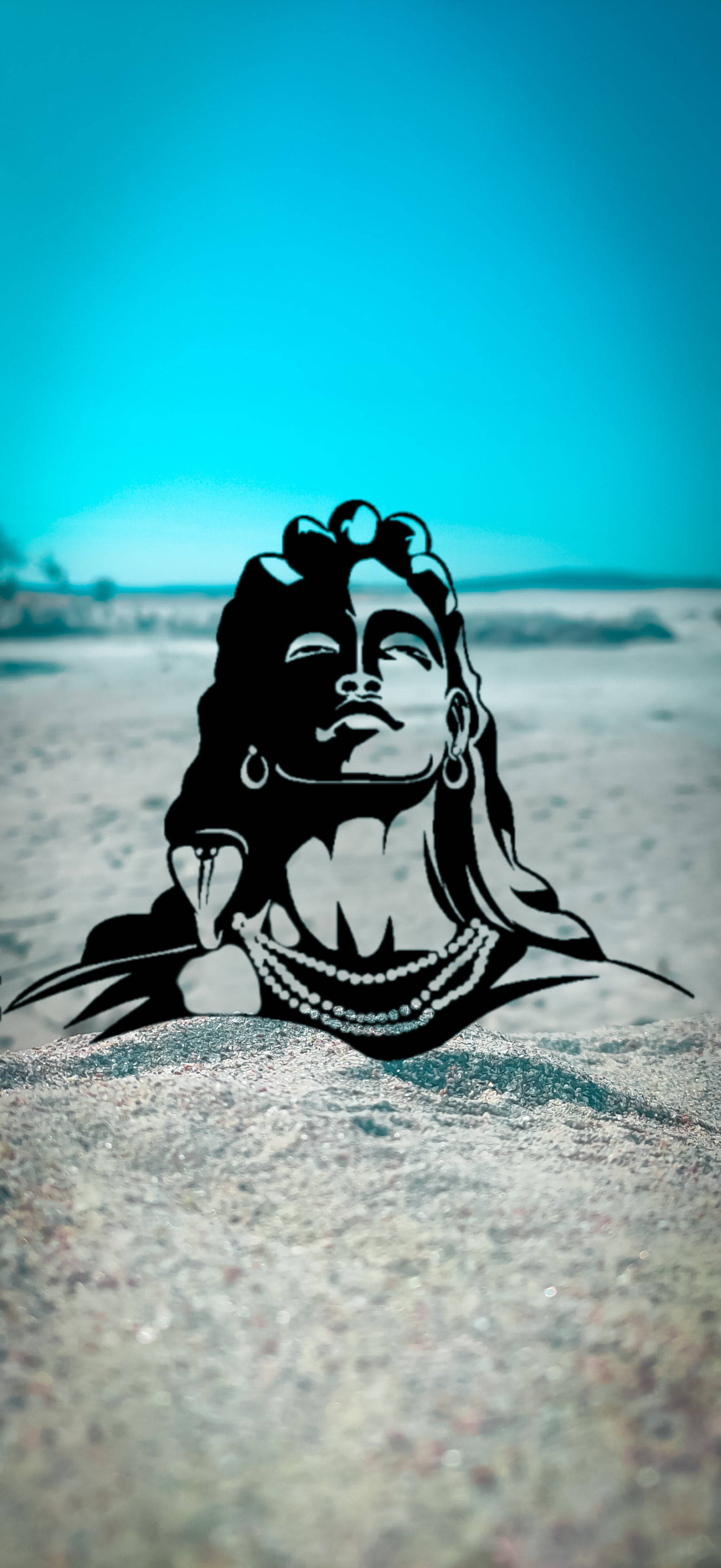 shiva iPhone 桌布 壁紙 — 一個長髮戴珍珠的寧靜女性的黑色剪影，躺在沙地上，背景是充滿活力的藍綠色天空。