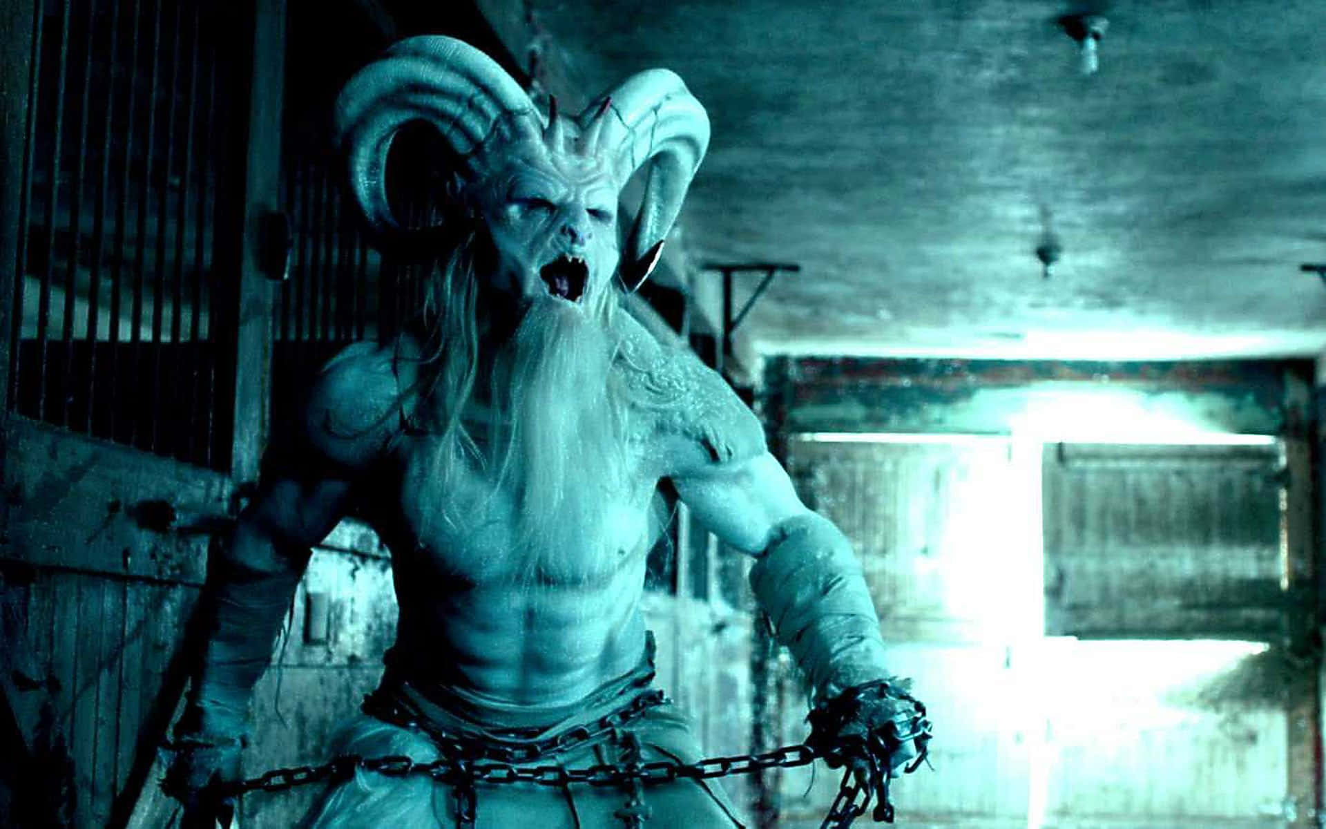 Krampus 桌布 壁紙 — 一個長鬍子、有角的惡魔般人物在昏暗、鎖鏈束縛的監獄牢房中咆哮。