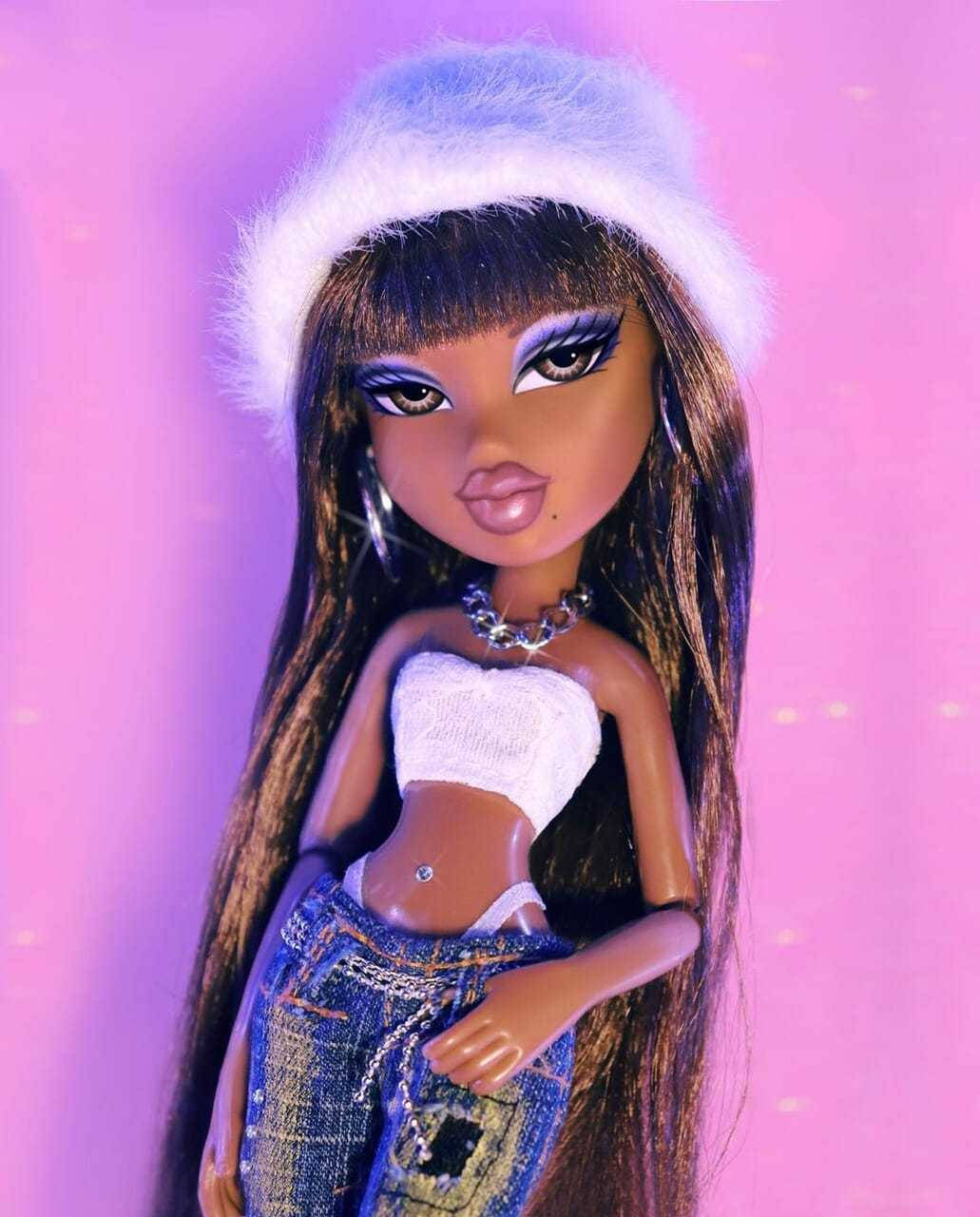Bratz 桌布 壁紙 — 一個長黑髮、紫色眼影的 Bratz 公仔，戴著白色毛絨帽和牛仔褲，背景是發光的粉紅色。