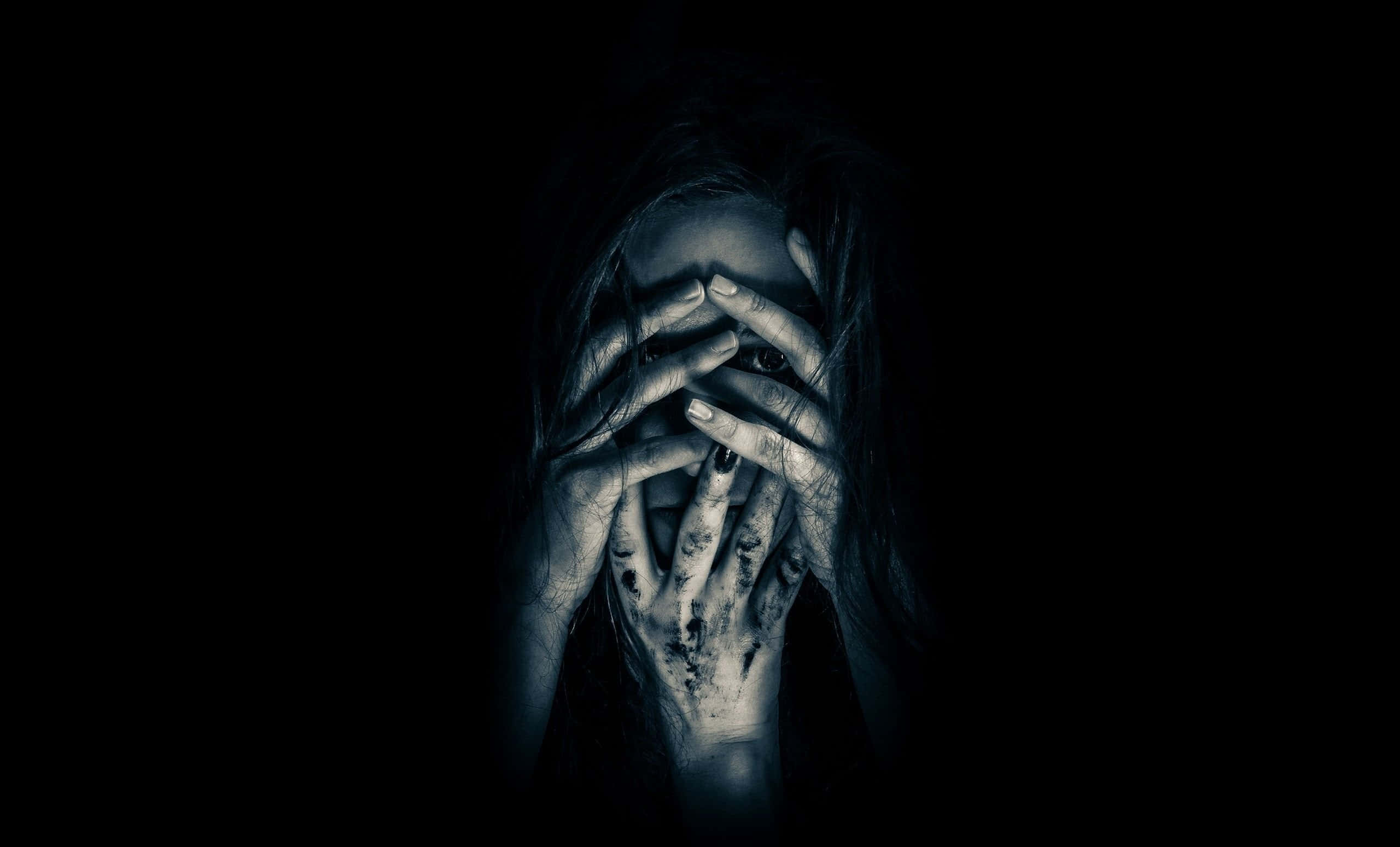 Dark Fear 桌布 壁紙 — 一個長黑髮的人用骯髒的手遮住臉，背景為黑色。