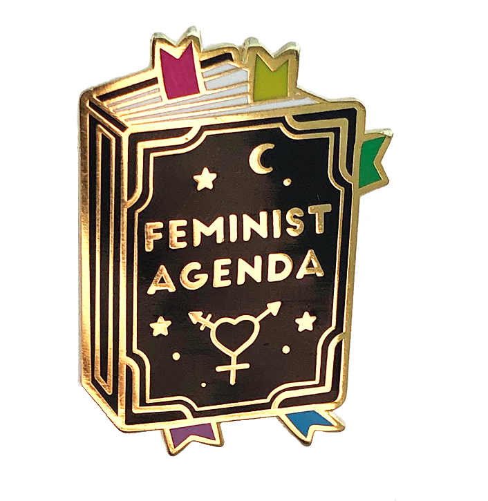 Pin Icon 桌布 壁紙 — 一個閃亮的琺瑯別針，形狀像一本名為「FEMINIST AGENDA」的書，帶有金色邊飾、星星、月亮和性別符號。