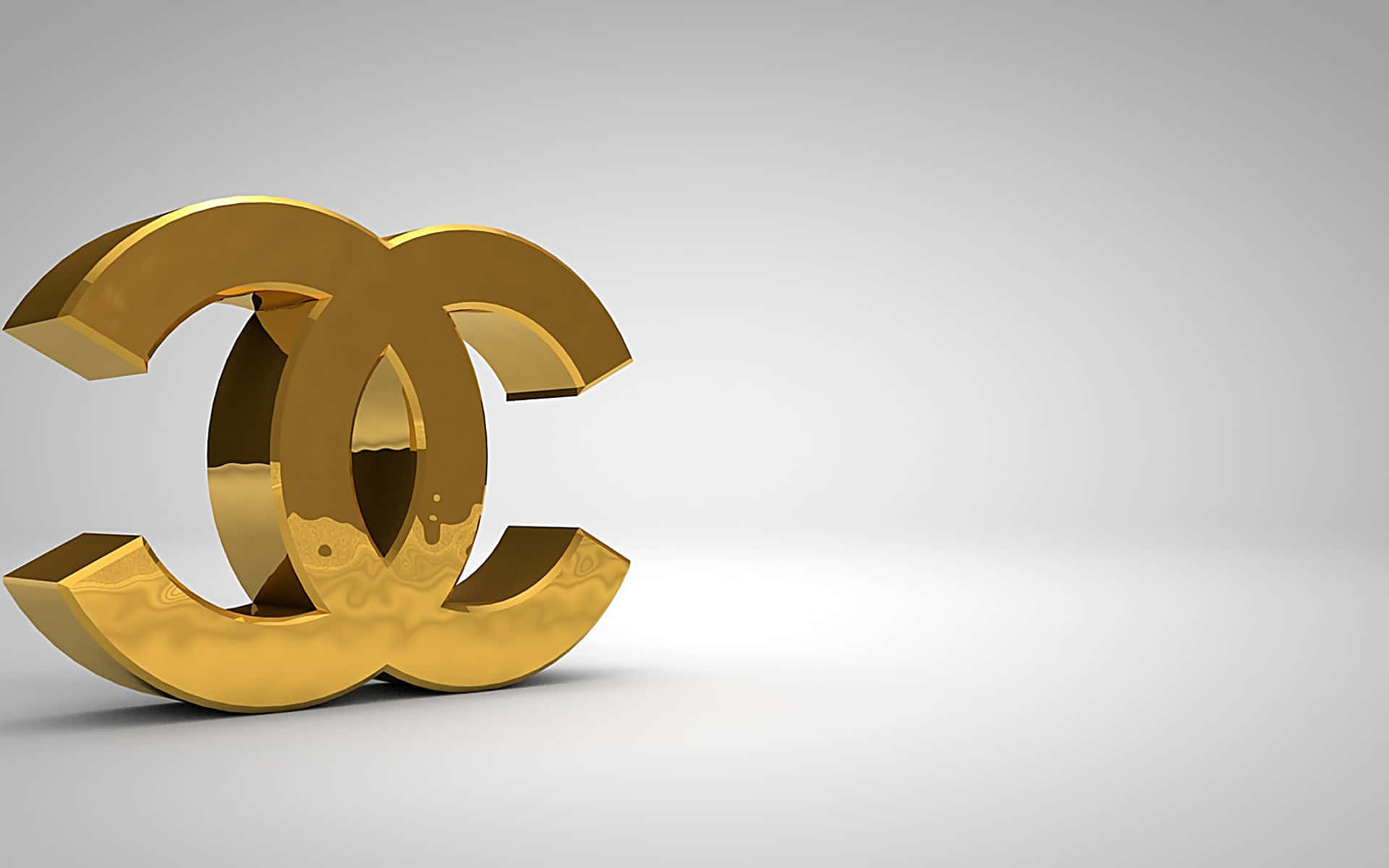 Chanel 桌布 壁紙 — 一個閃亮的金色Chanel標誌，以3D呈現，帶有柔和陰影，置於簡約白色背景上。
