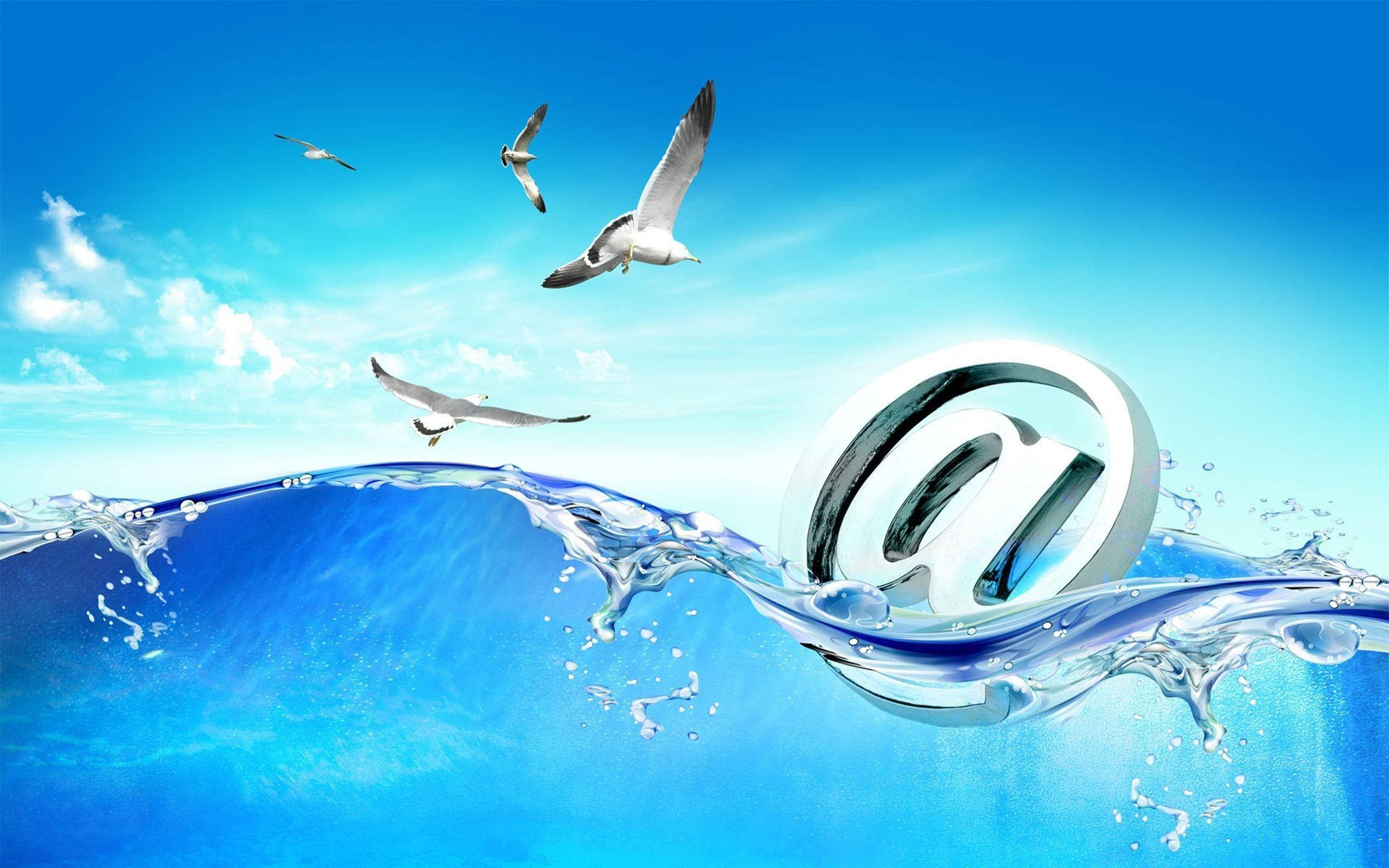 Email 桌布 壁紙 — 一個閃亮的銀色@符號從動態的藍色海浪中浮現，背景是晴朗的天空和海鷗翱翔。