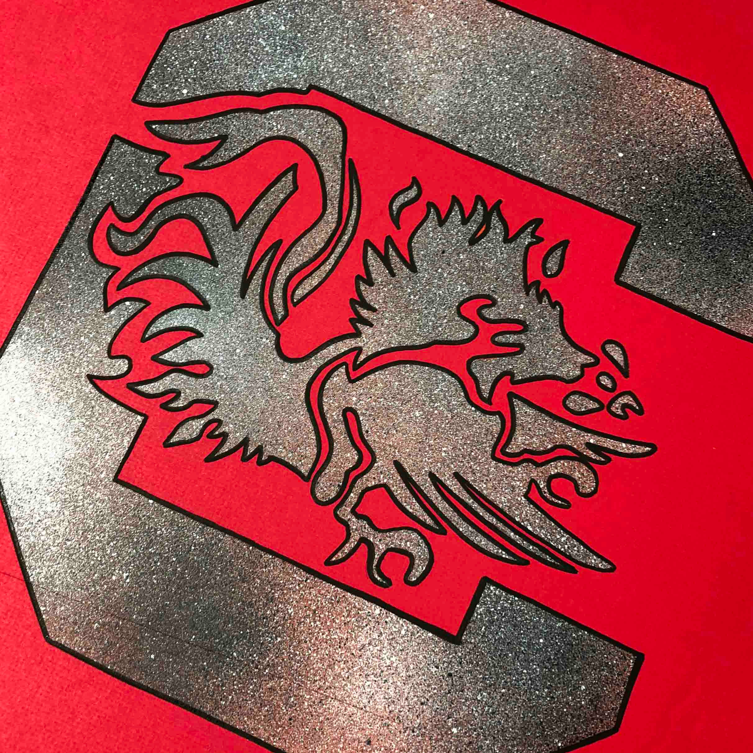 South Carolina Gamecocks 桌布 壁紙 — 一個閃亮的銀色獅鷲標誌，黑色輪廓，大膽地放在一個大字母S內，背景是鮮紅色。
