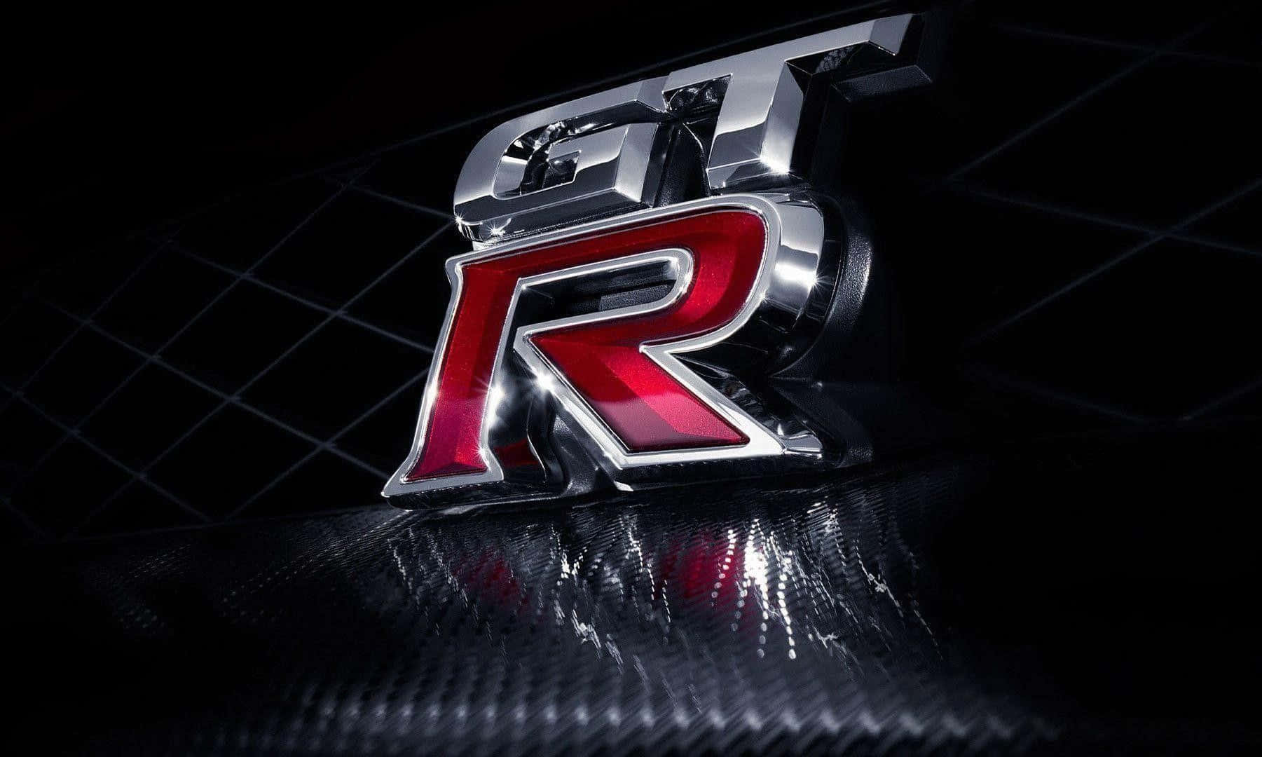在碳纖維表面上的鍍鉻和紅色GT-R標誌，帶有反射高光。 — Valorant Logo 壁紙