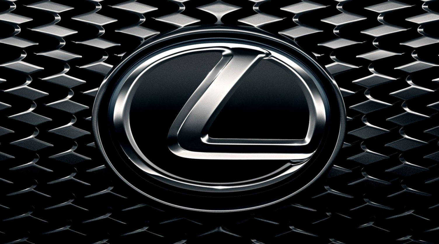 Lexus 標誌 桌布 壁紙 — 一個閃亮鍍鉻 Lexus 標誌的特寫，位於黑色鑽石紋格柵中央，帶有銳利反射。